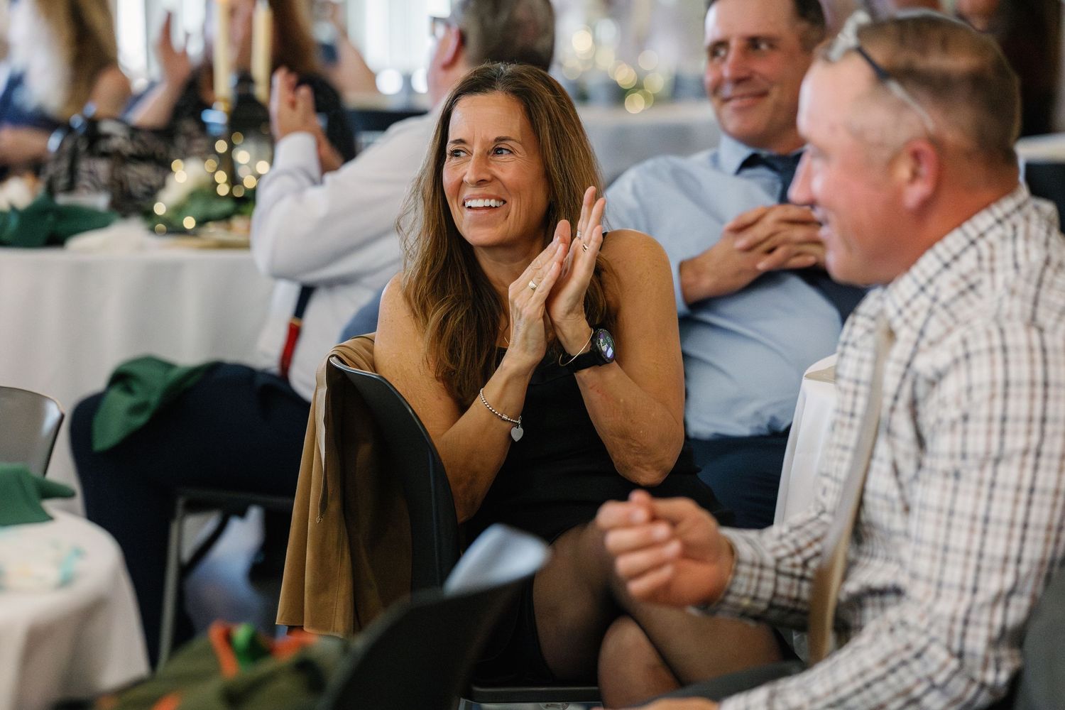 People laughing and enjoying conversation at a social gathering around a table.