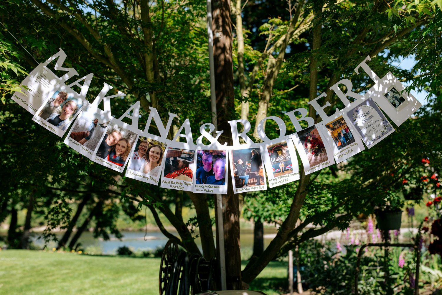 Wedding photo banner displaying polaroid pictures of couple Makana and Robert hanging from a tree outdoors.