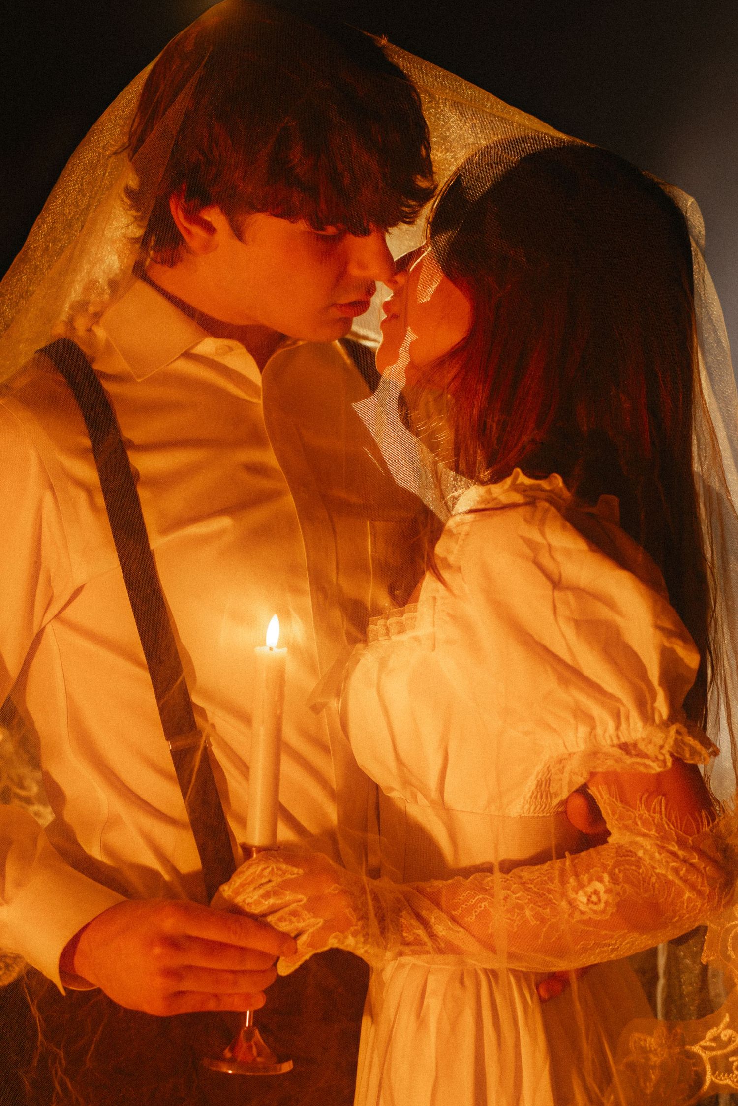 Atmospheric candlelit scene with figures in white dresses creating a romantic vintage mood.