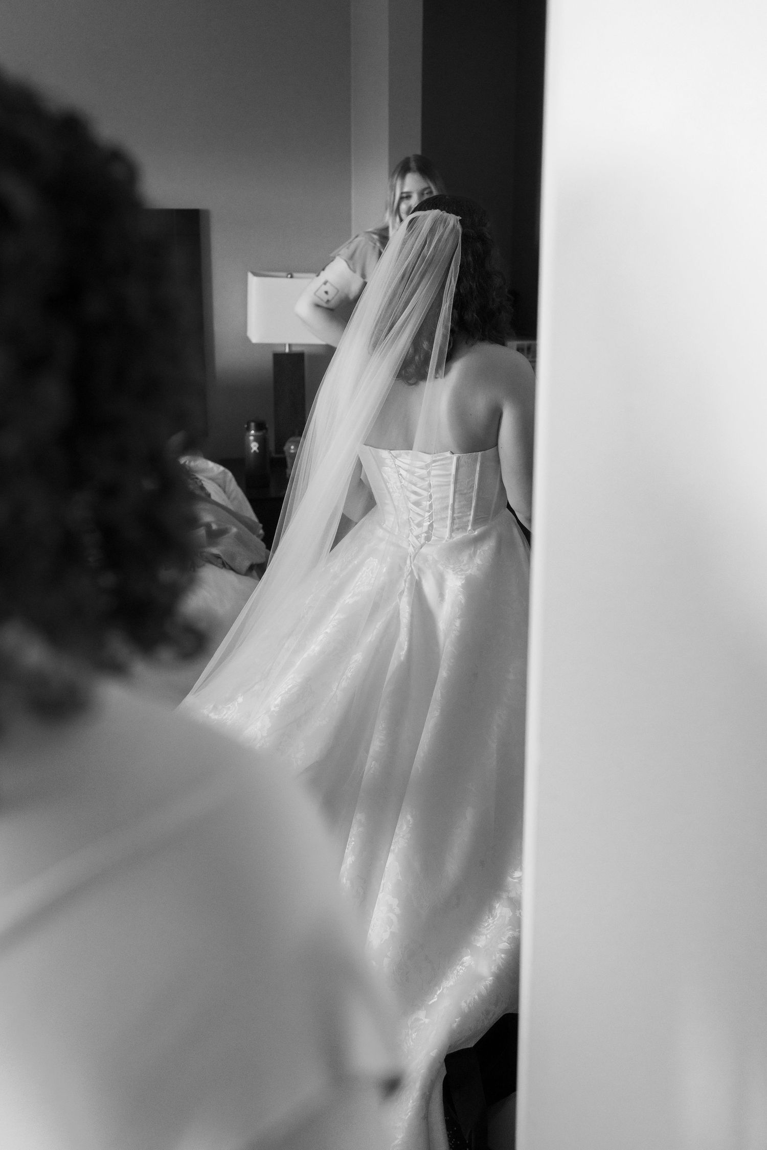 Close-up details of a white wedding dress with delicate lace and corset back.