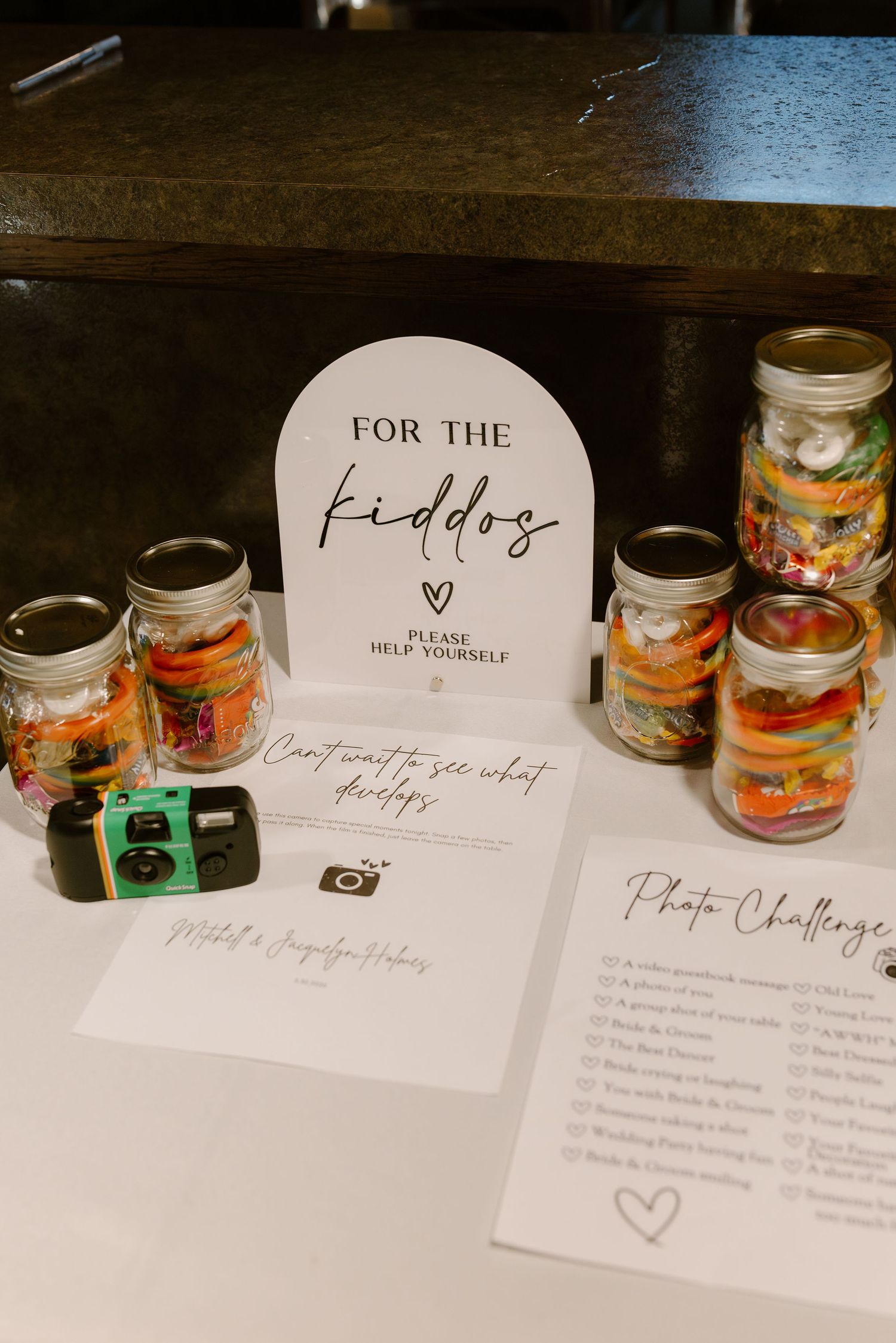 Wedding kids table with mason jar crafts, disposable camera, and photo challenge activity cards.