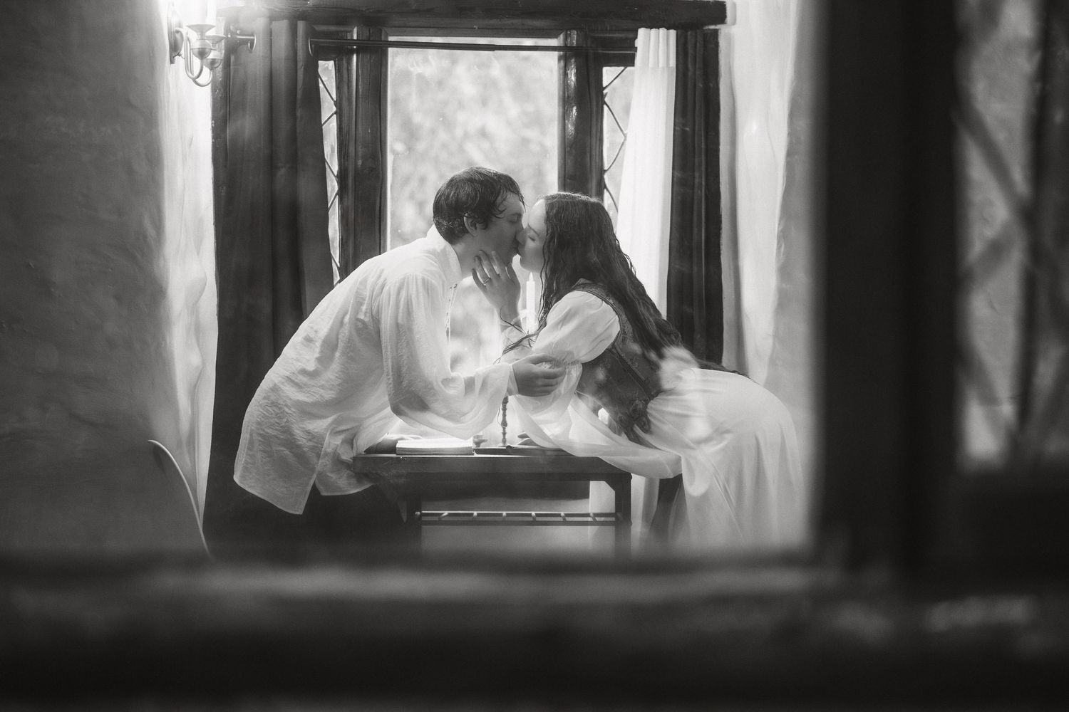 An intimate black and white portrait sequence through a window frame.