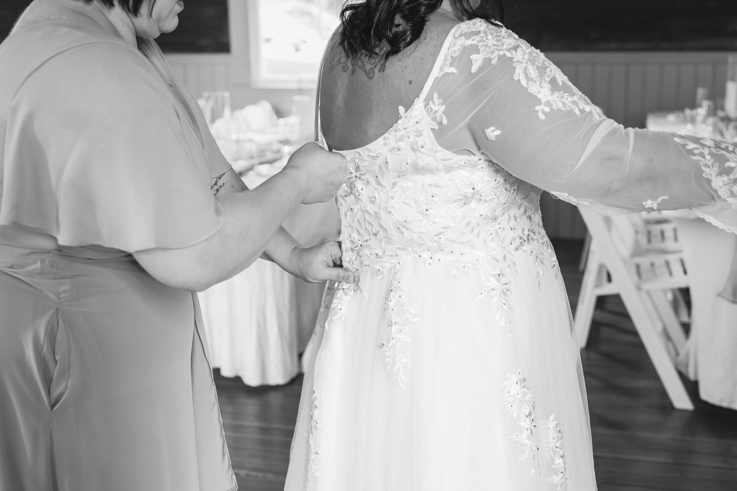 Close-up of wedding dress details being adjusted.