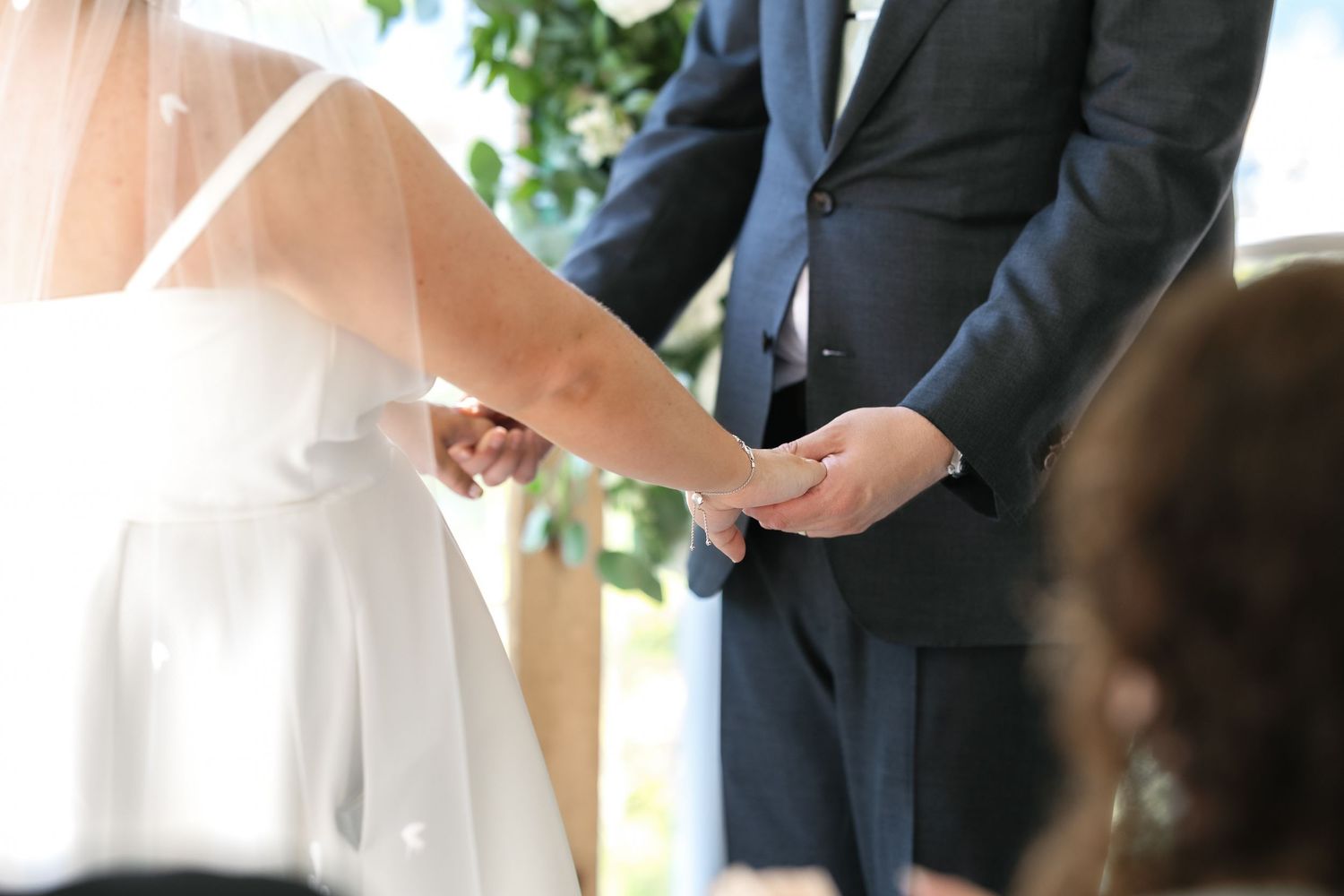 Wedding ceremony moments captured during vow exchanges at an outdoor venue.