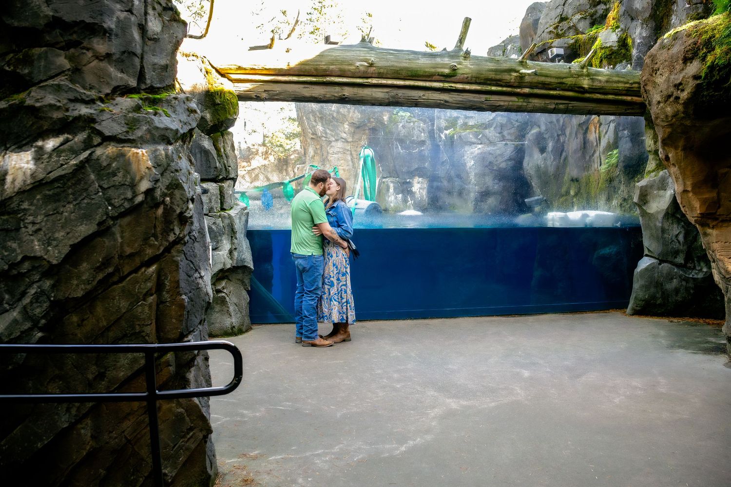 Dark stone archways and walls create a tunnel-like viewing area in an aquarium exhibit.