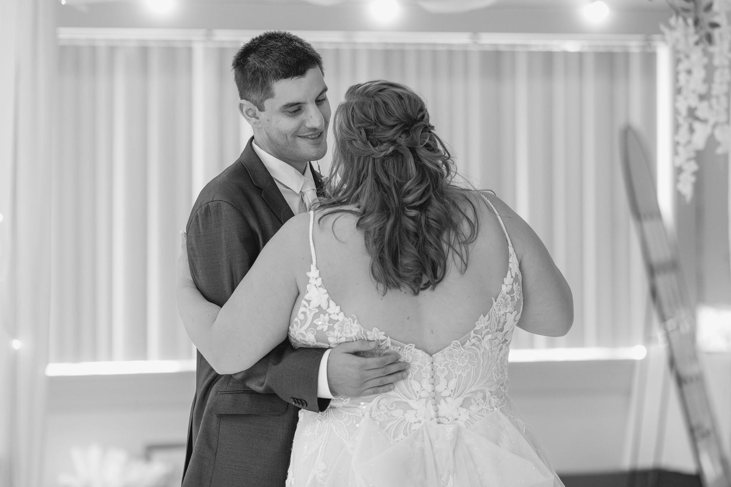 Wedding couple shares an intimate first dance moment under soft lighting at their reception.