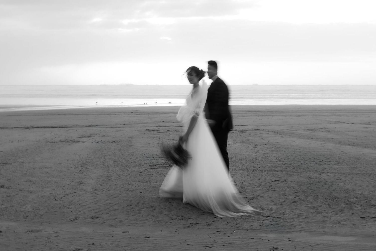 A romantic sequence of black and white photos showing a couple dancing on a misty beach at sunset.