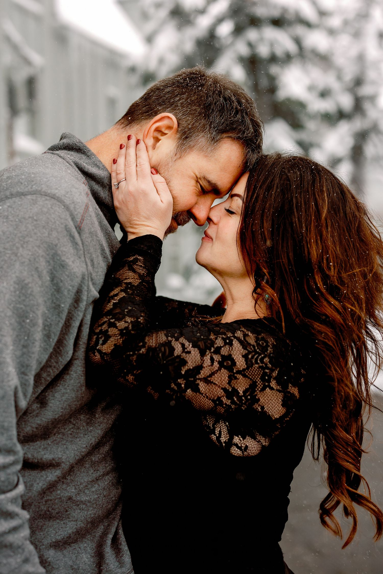 A romantic couple shares intimate winter moments in a series of close embraces while wearing grey and black attire.