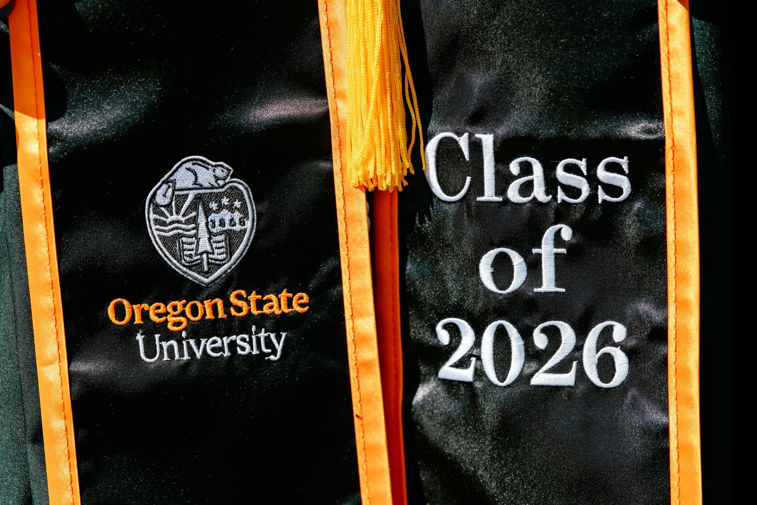 Oregon State University Class of 2026 graduation stole with gold tassel on black satin fabric.