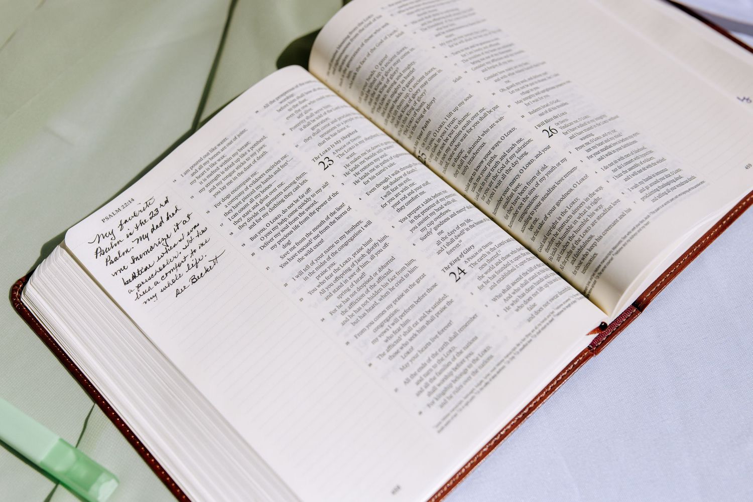 Open Bible with handwritten notes on the pages resting on a white surface.