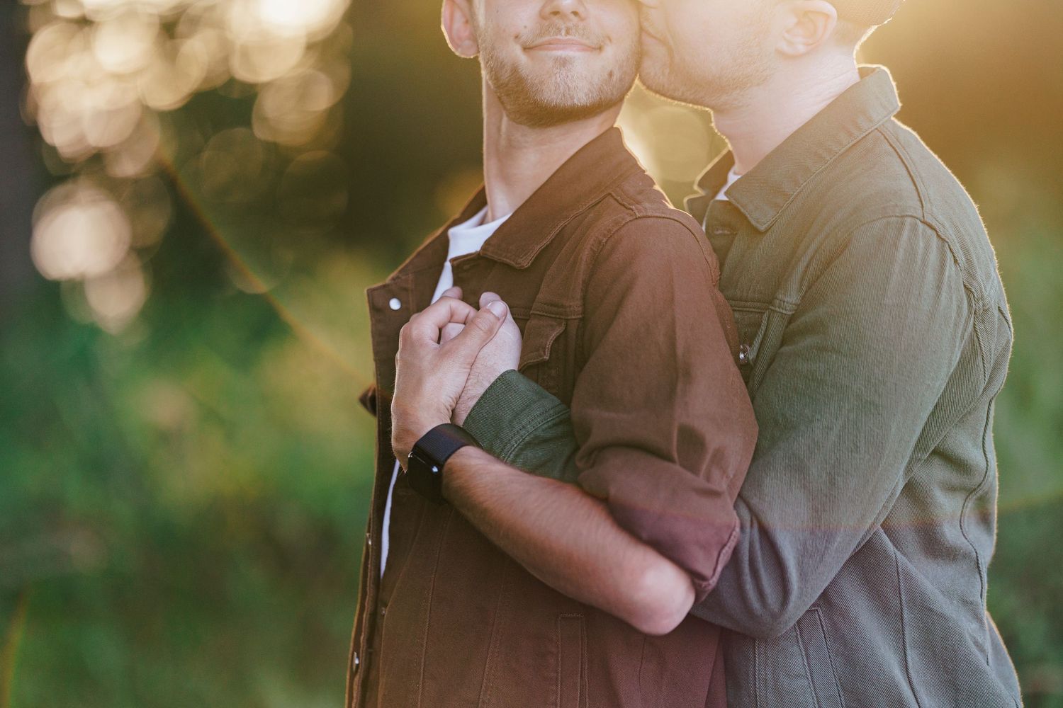 Golden-hour backlit couple in an intimate embrace shares a romantic dance together in a sunlit outdoor setting.