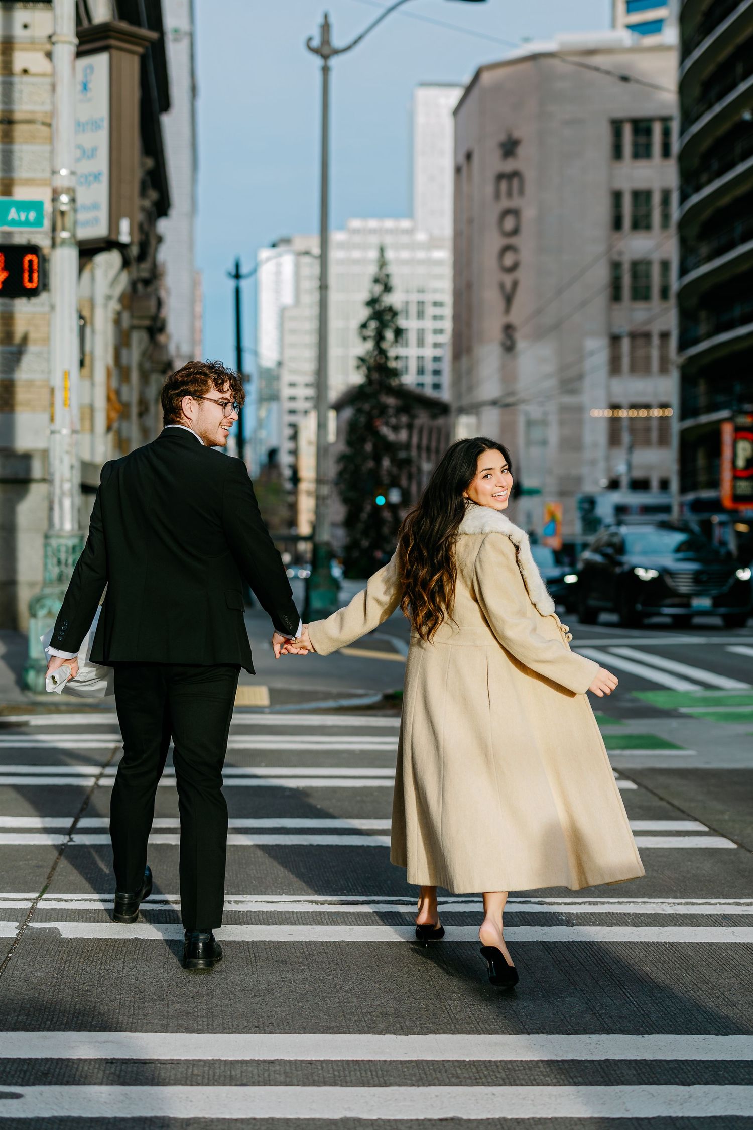 A couple holding hands while crossing a city street in Seattle.
