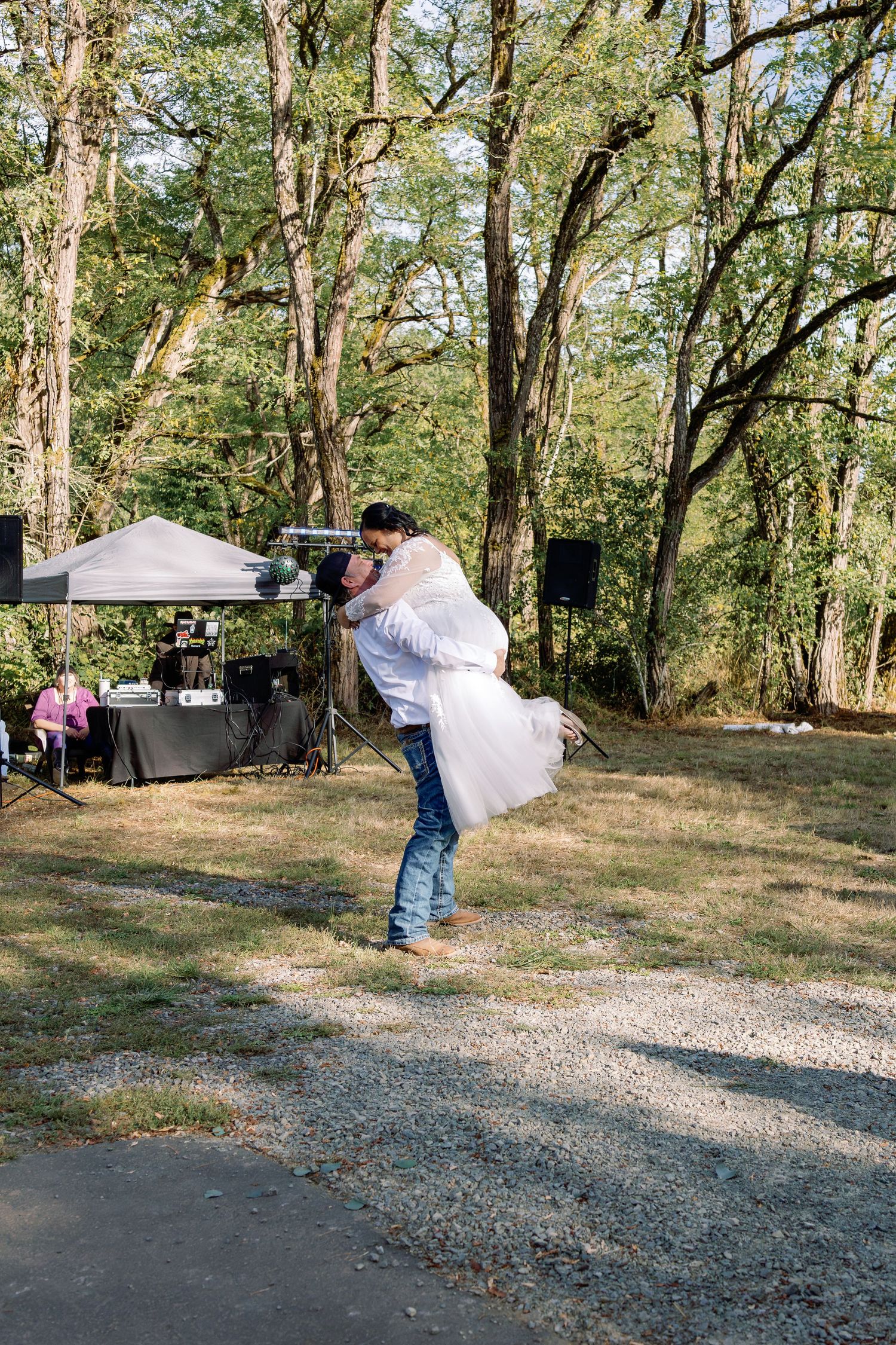 A romantic outdoor wedding dance sequence shows a couple spinning in a wooded area with gravel ground.