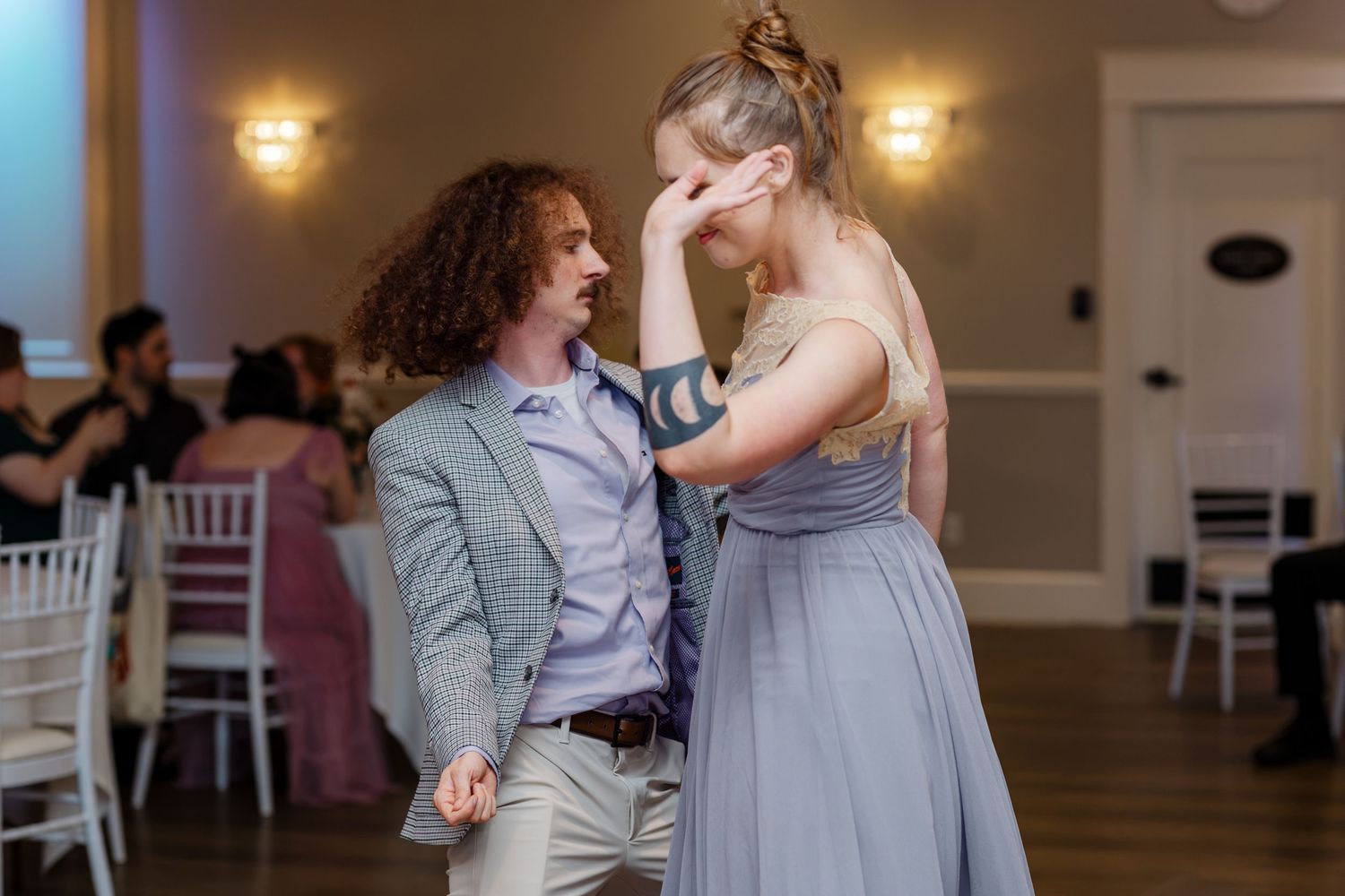 Couple shares a joyful dance together during wedding reception in elegant ballroom.