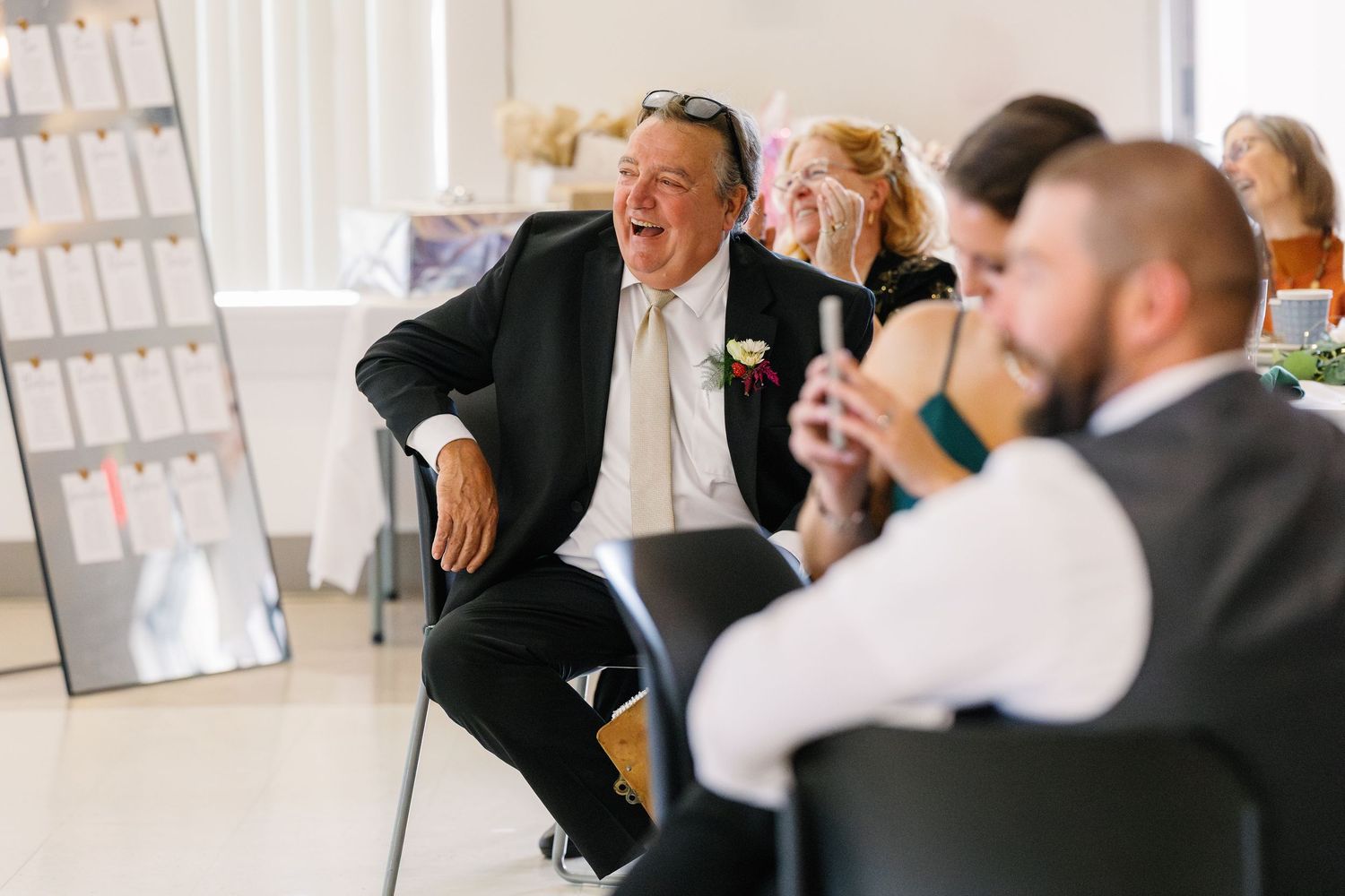 Wedding guests sharing laughter and joyful moments during the ceremony.