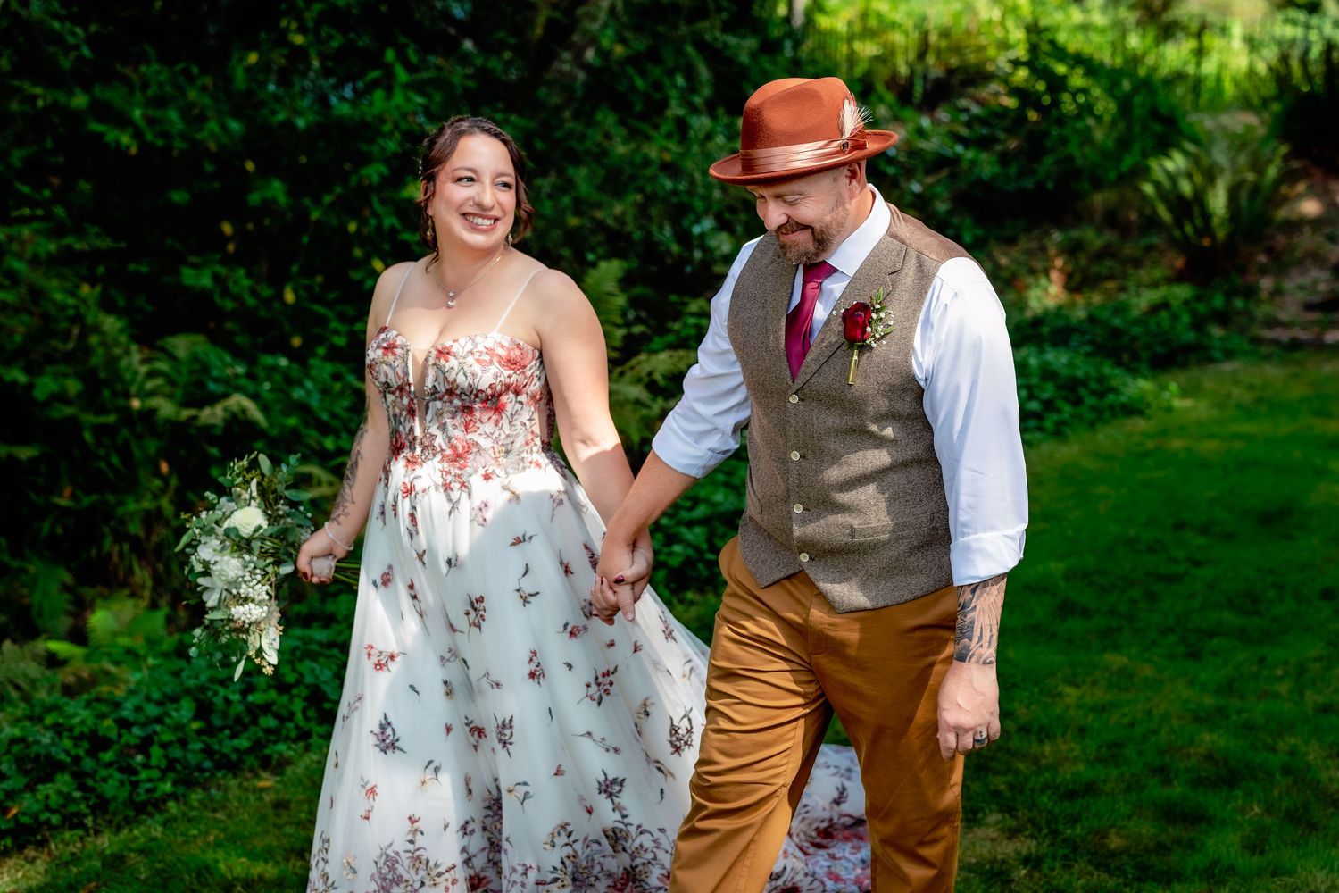 A couple shares a tender moment in a lush garden setting during a celebration.