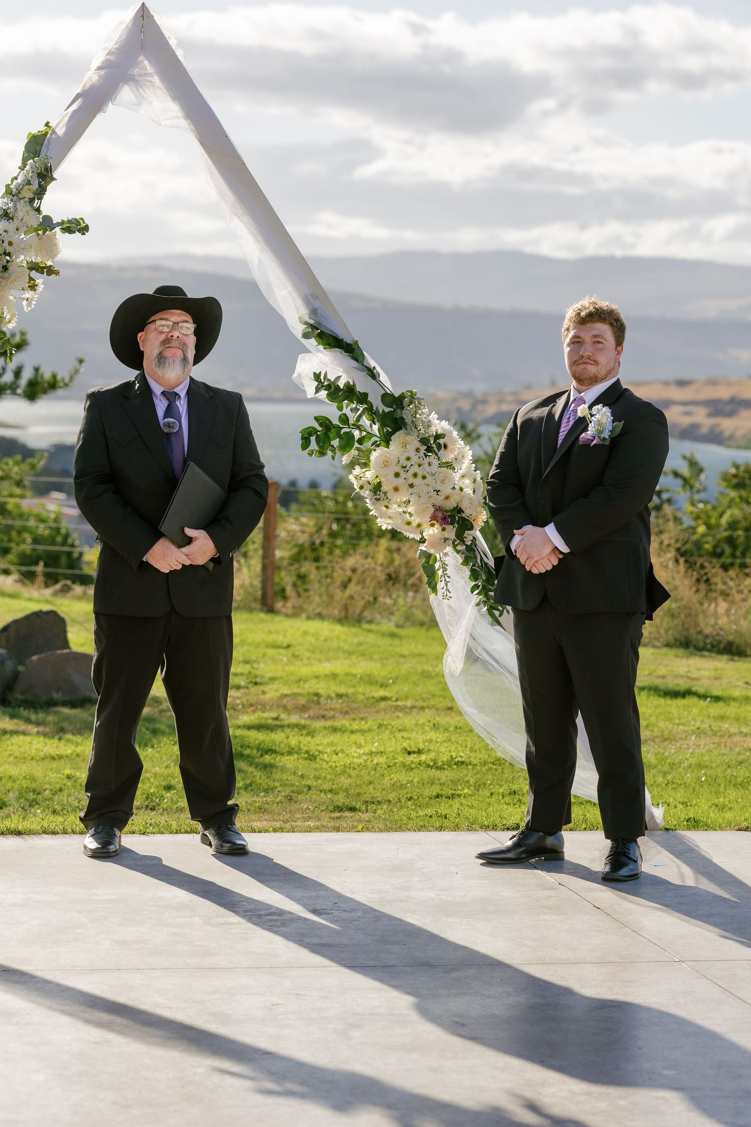 A sequence of playful wedding party photos showing groomsmen peeking behind a white curtain outdoors with mountains in background.