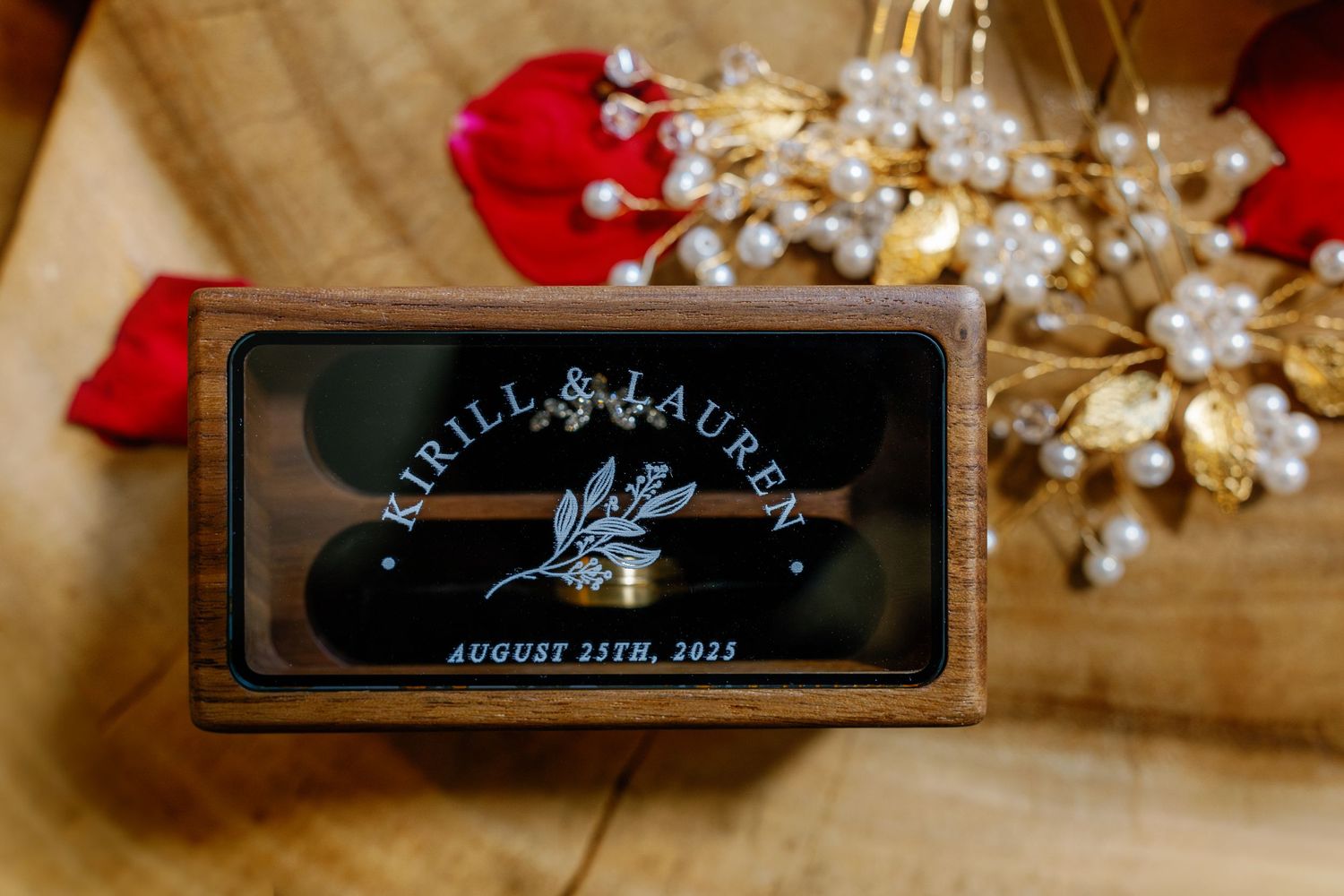 Wedding decor featuring red rose petals and crystal details with elegant signage.