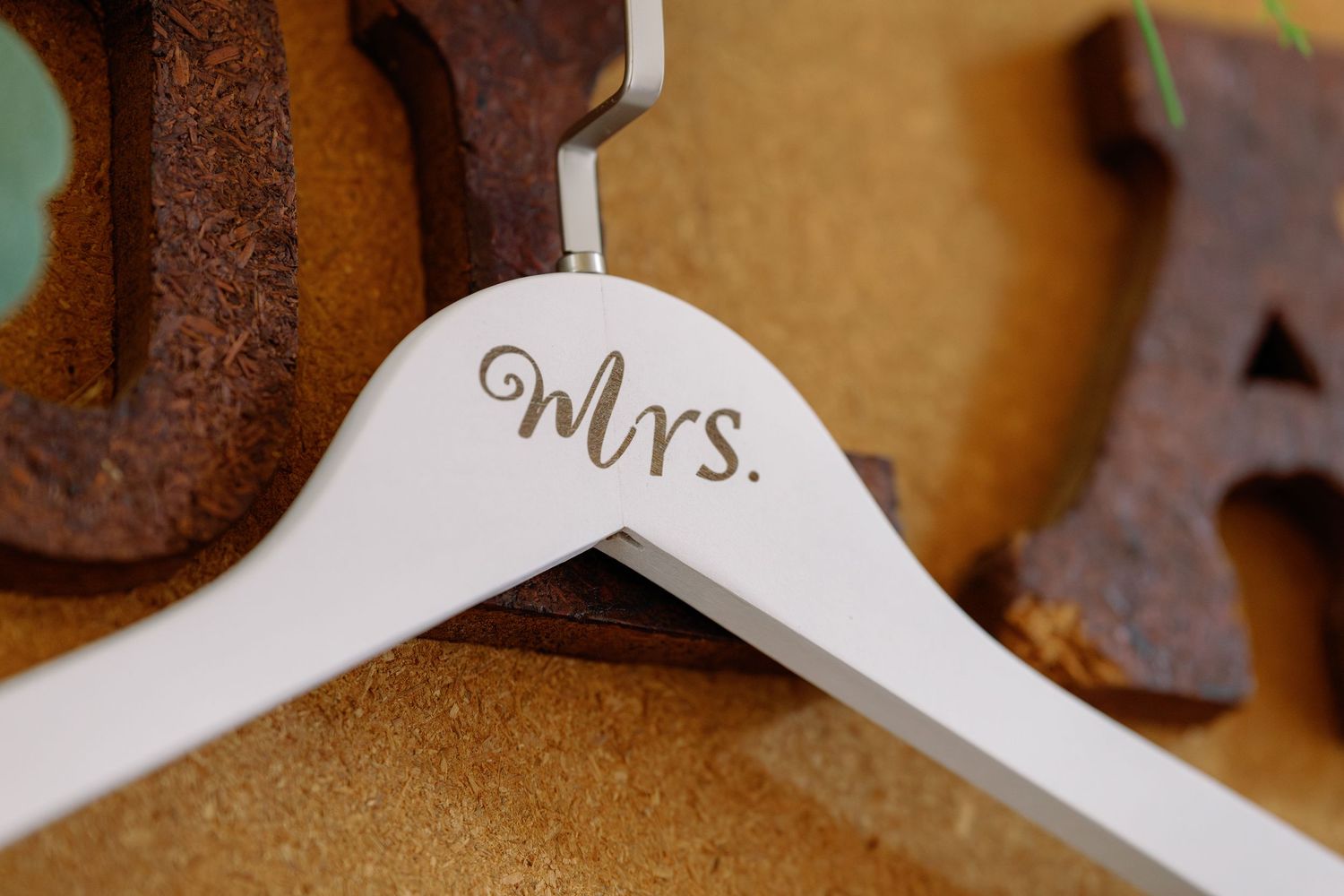Rustic wedding decor featuring wooden letters spelling 'Mr' and 'Mrs' against a brown background.