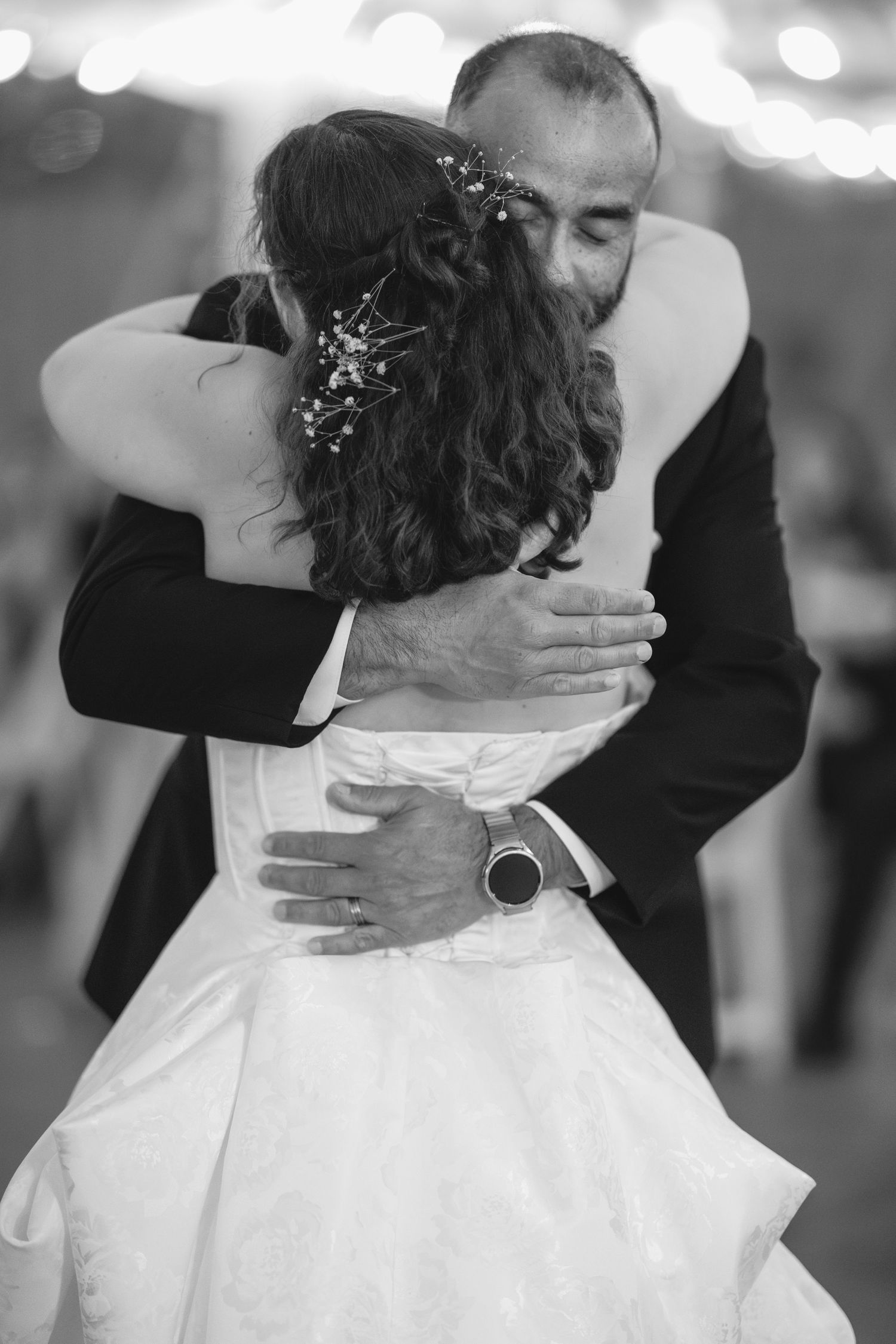Black and white dance photos showing embraces between wedding guests in formal attire.