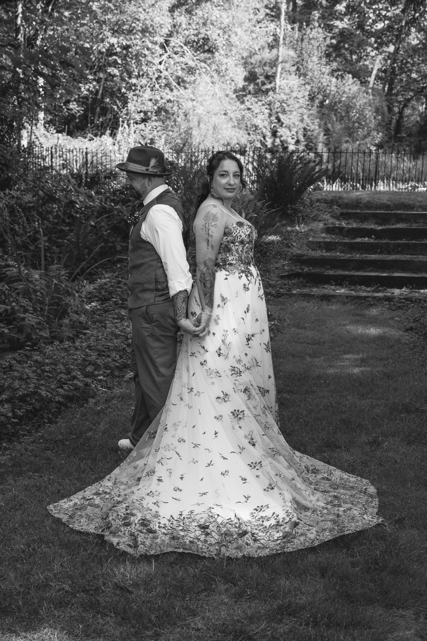 A romantic black and white wedding photo series showing a couple embracing on a grassy lawn.