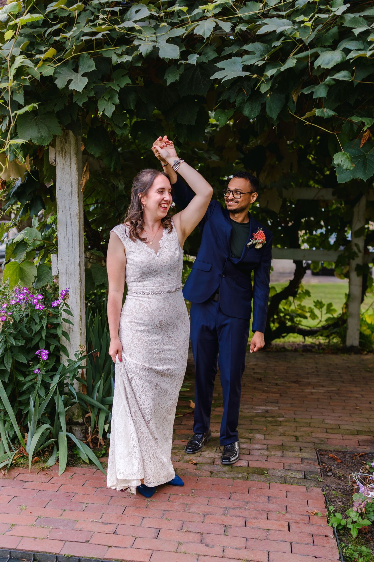 Couple dancing and celebrating on a brick patio surrounded by greenery.