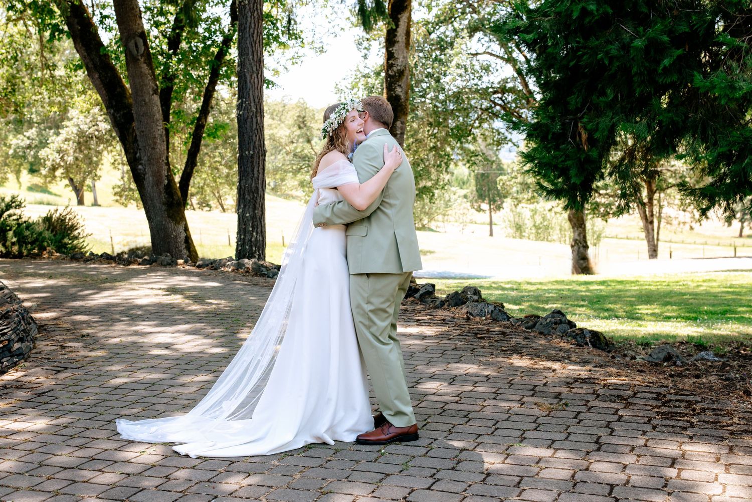 Bride and groom sharing a romantic kiss in an outdoor garden setting on their wedding day.
