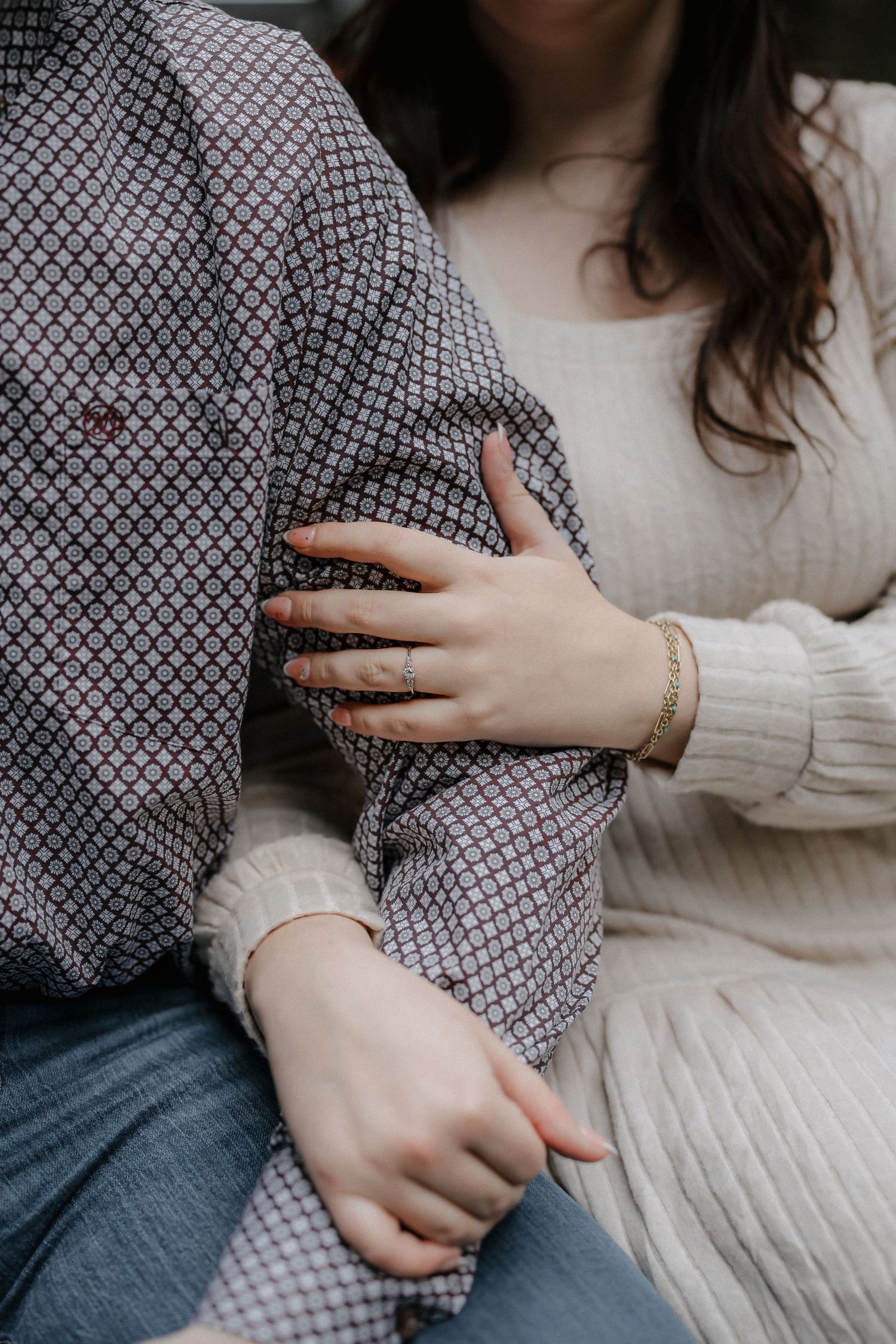 A sequence showing hands gently touching and holding a textured gray knit fabric against a neutral background.