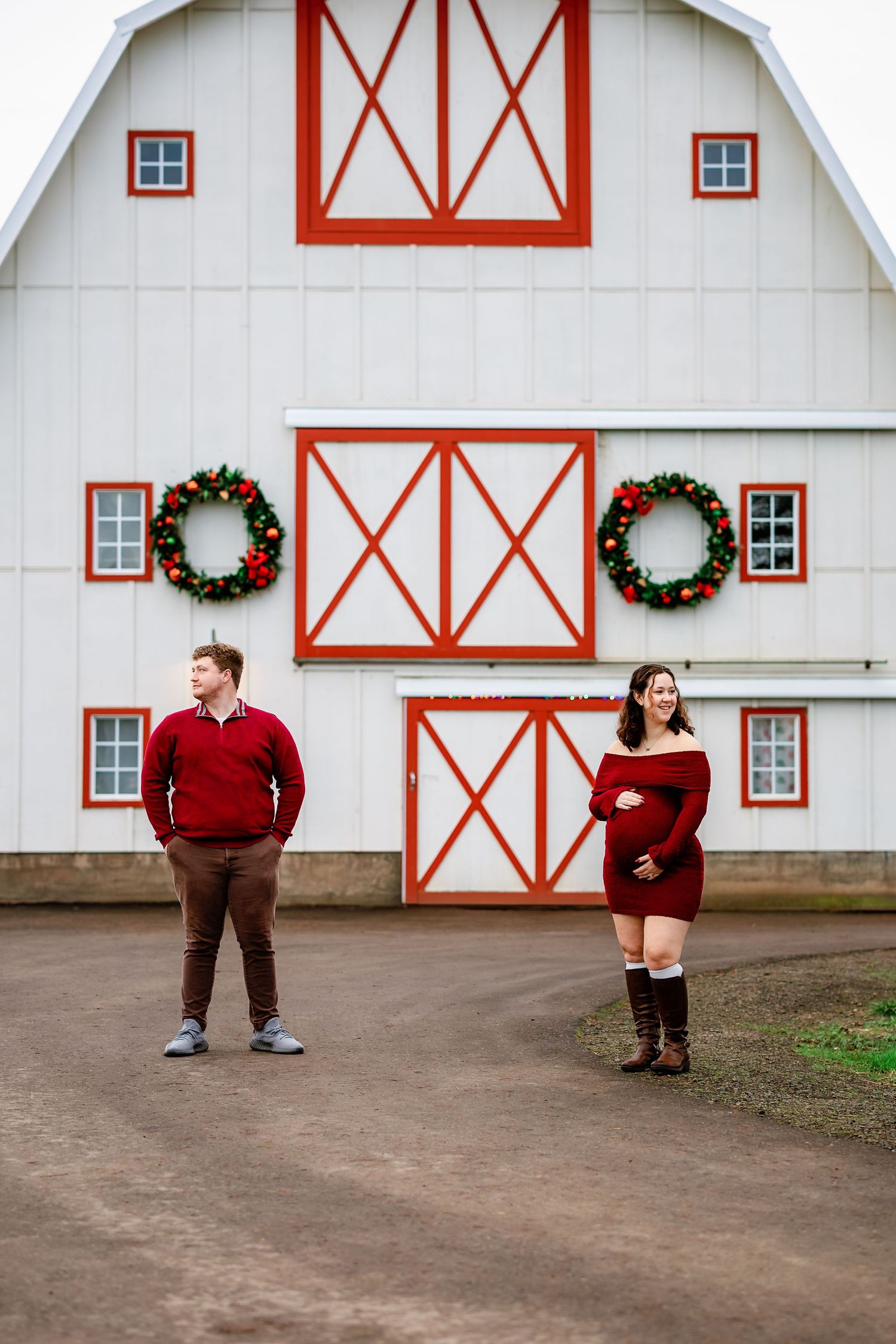 A series of holiday portraits in front of a white barn with red trim and Christmas wreaths.