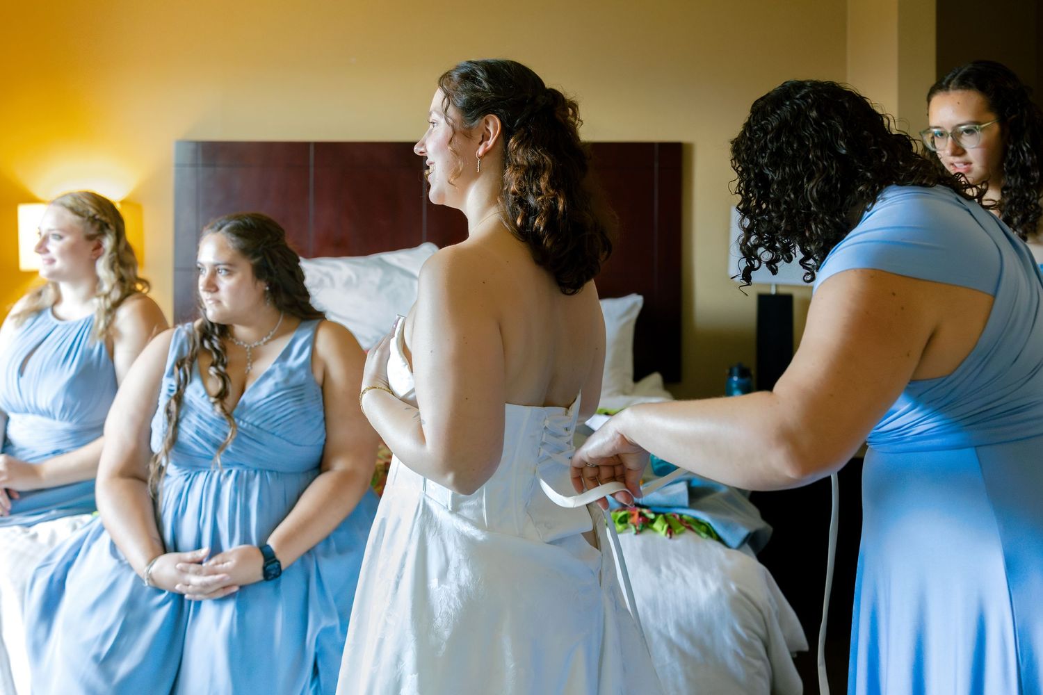 Bridesmaids in light blue dresses getting ready together before the wedding ceremony.