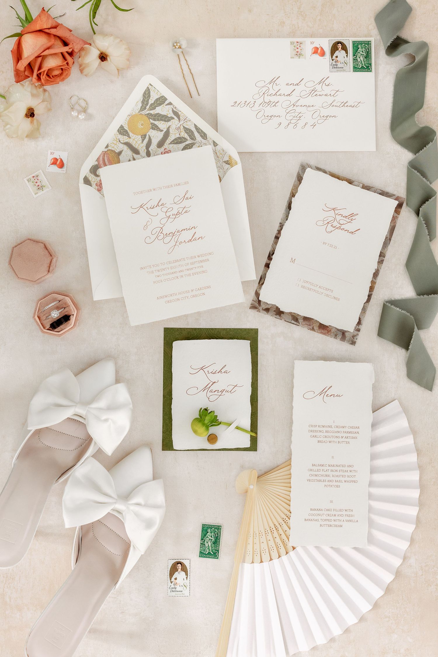 Wedding stationery suite featuring white paper fans, calligraphy invitations, and soft pink floral accents.