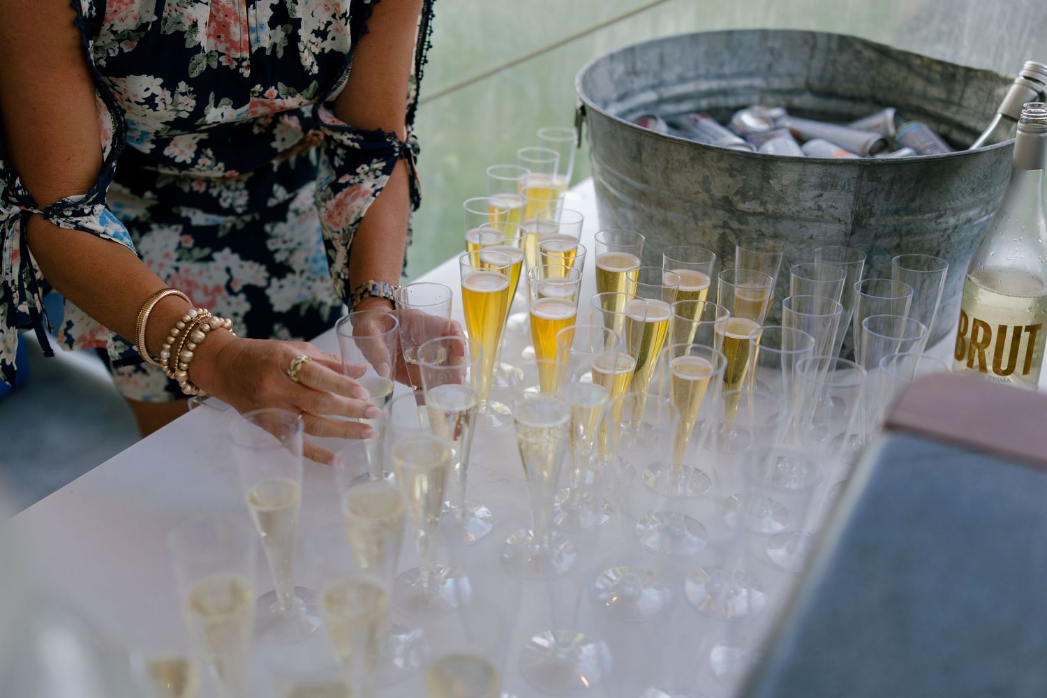 Rows of champagne glasses and drinks set up for wedding reception service.