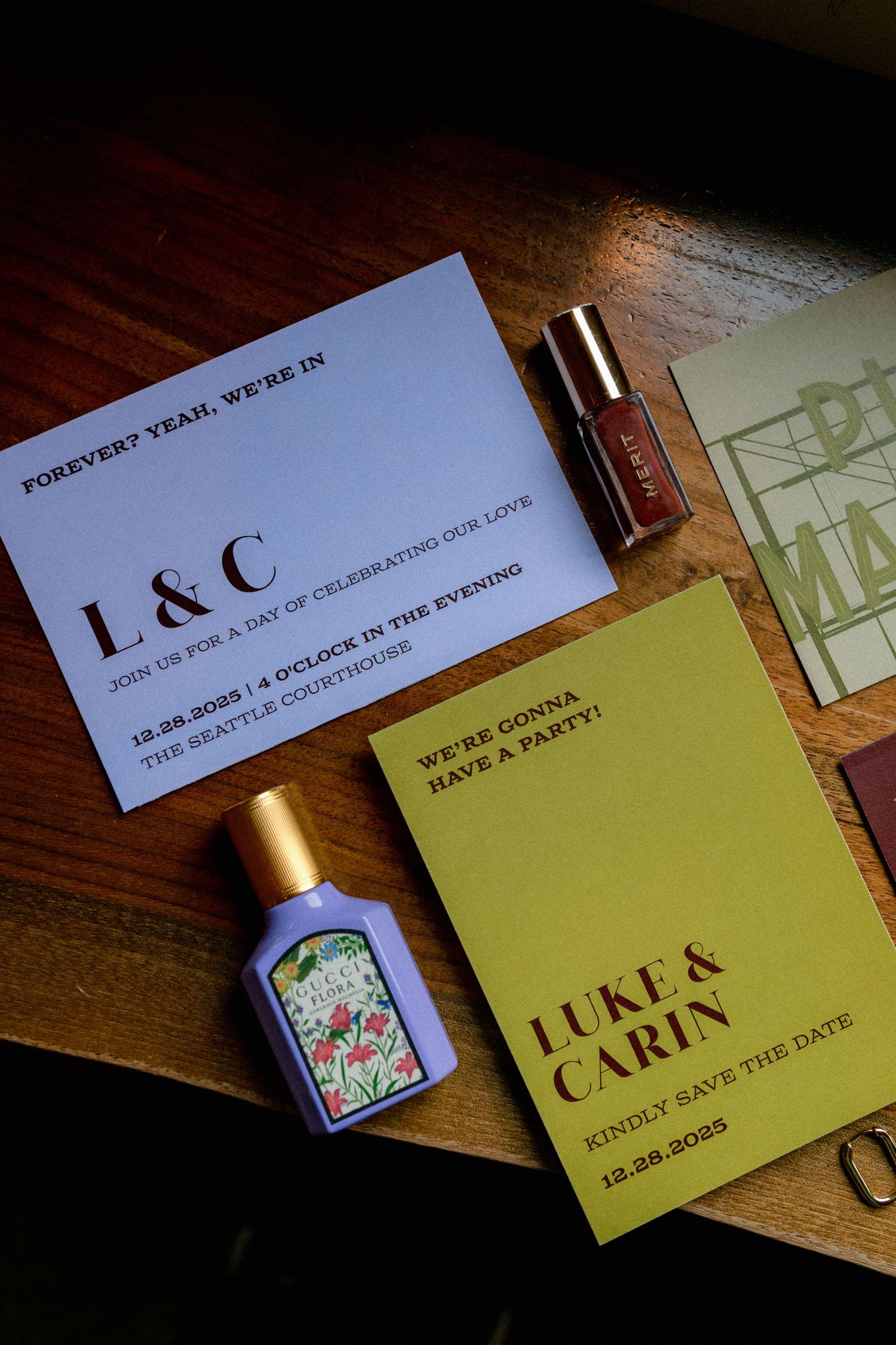 Wedding invitation cards and save the date notices arranged on dark wooden surface.