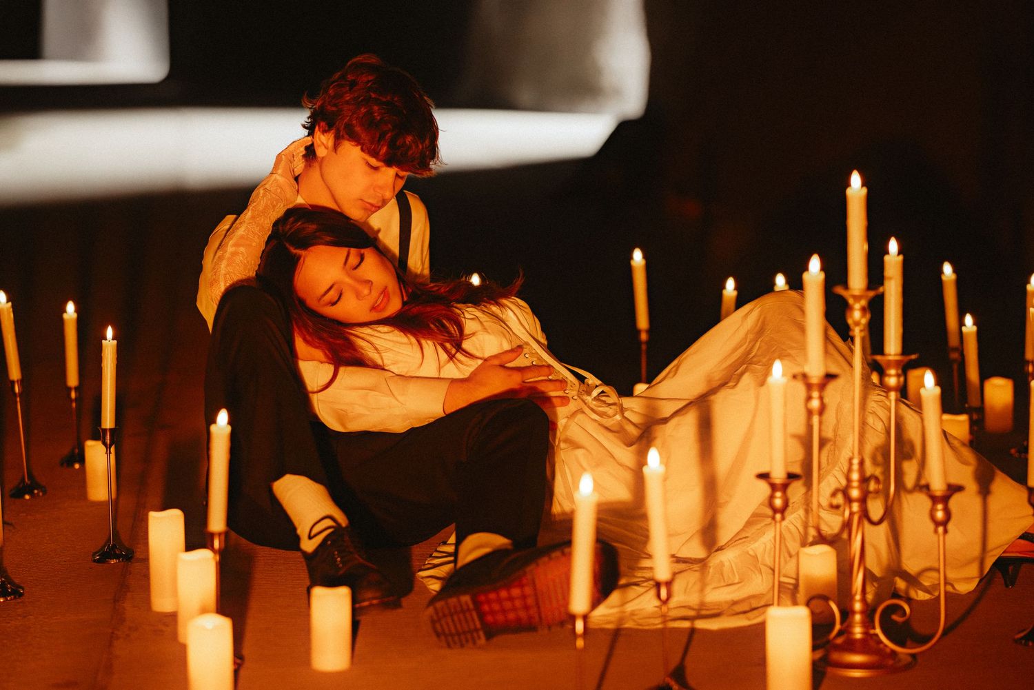 Several lit candles glow warmly in a dark setting creating an intimate and atmospheric ambiance.