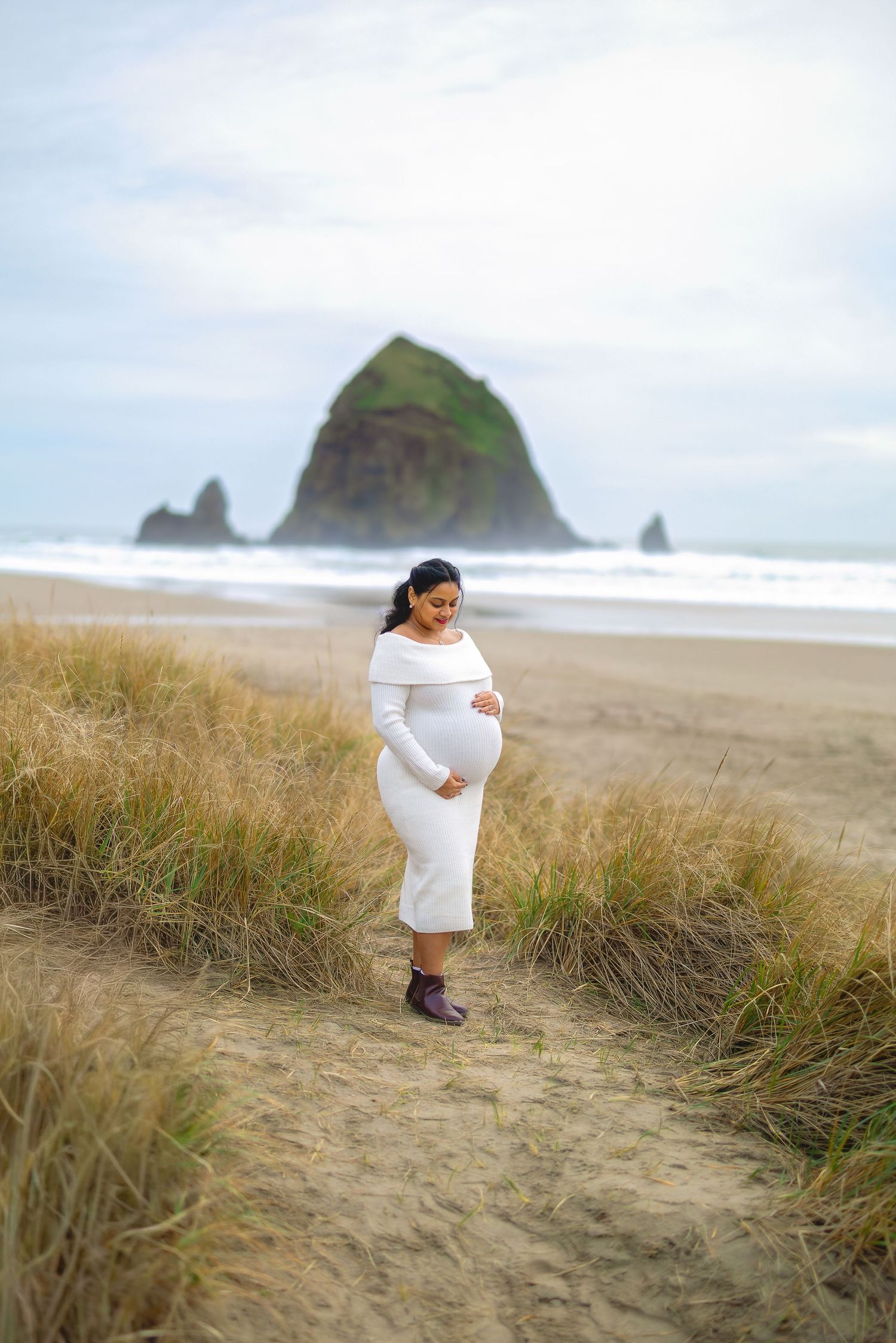 A series of photos showing someone in white walking along coastal sand dunes with a dramatic rocky beach landscape.