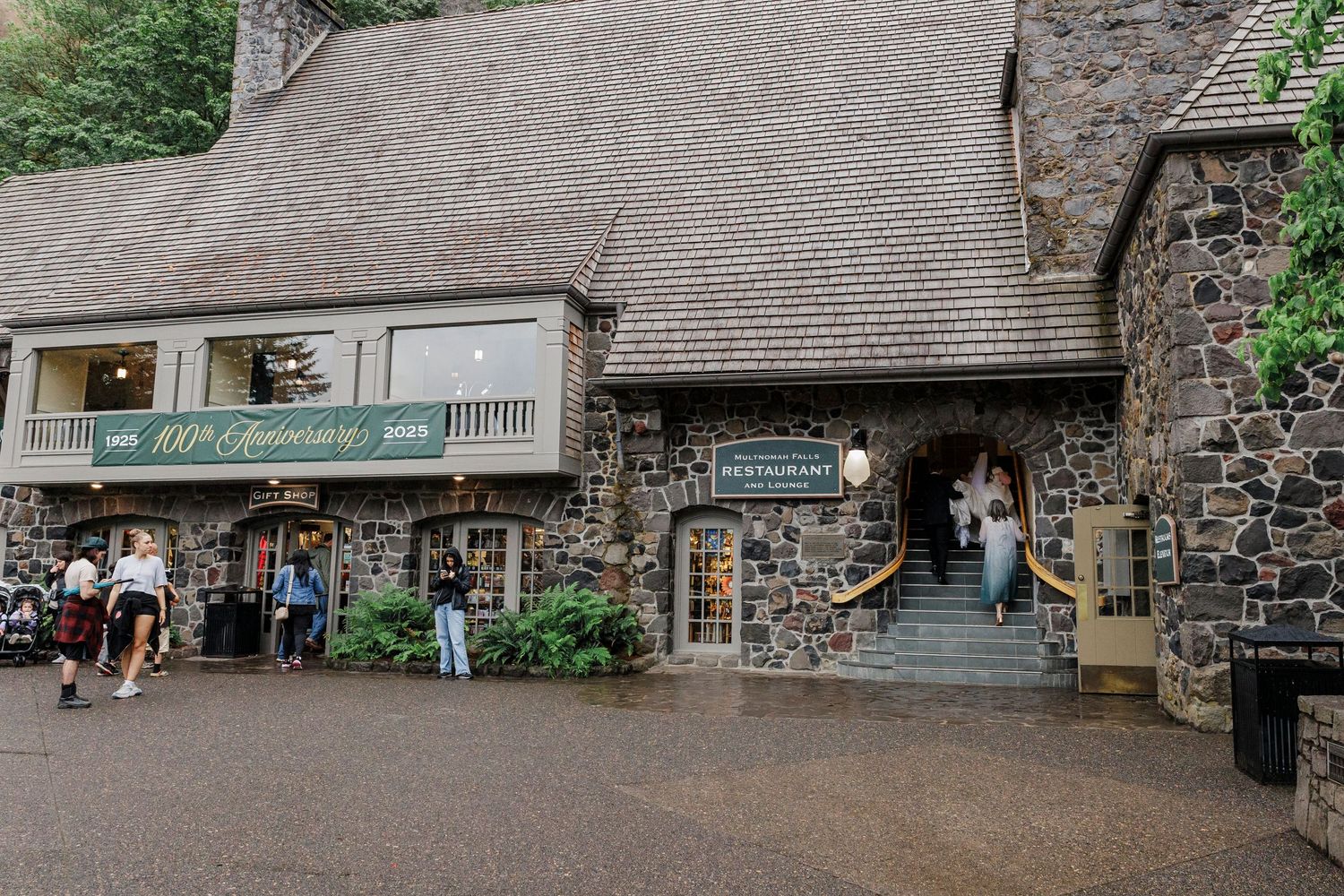 A rustic stone building entrance with stairs and archways leading to a visitor attraction entrance.