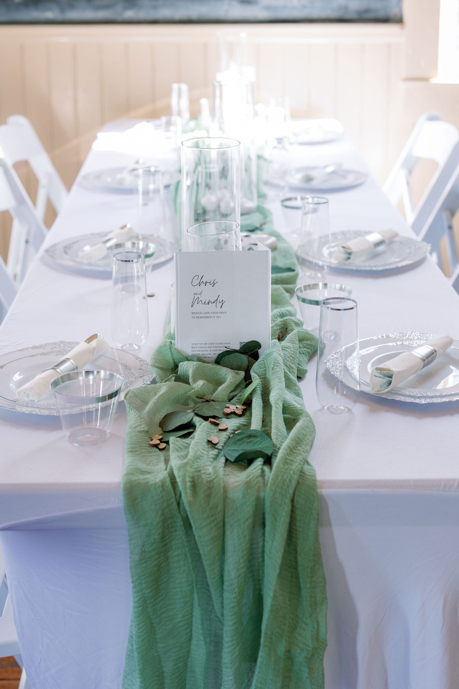 Elegant wedding table settings with white linens and sage green accents.