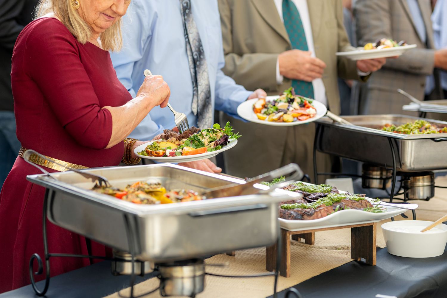 Guests serving themselves at wedding buffet.