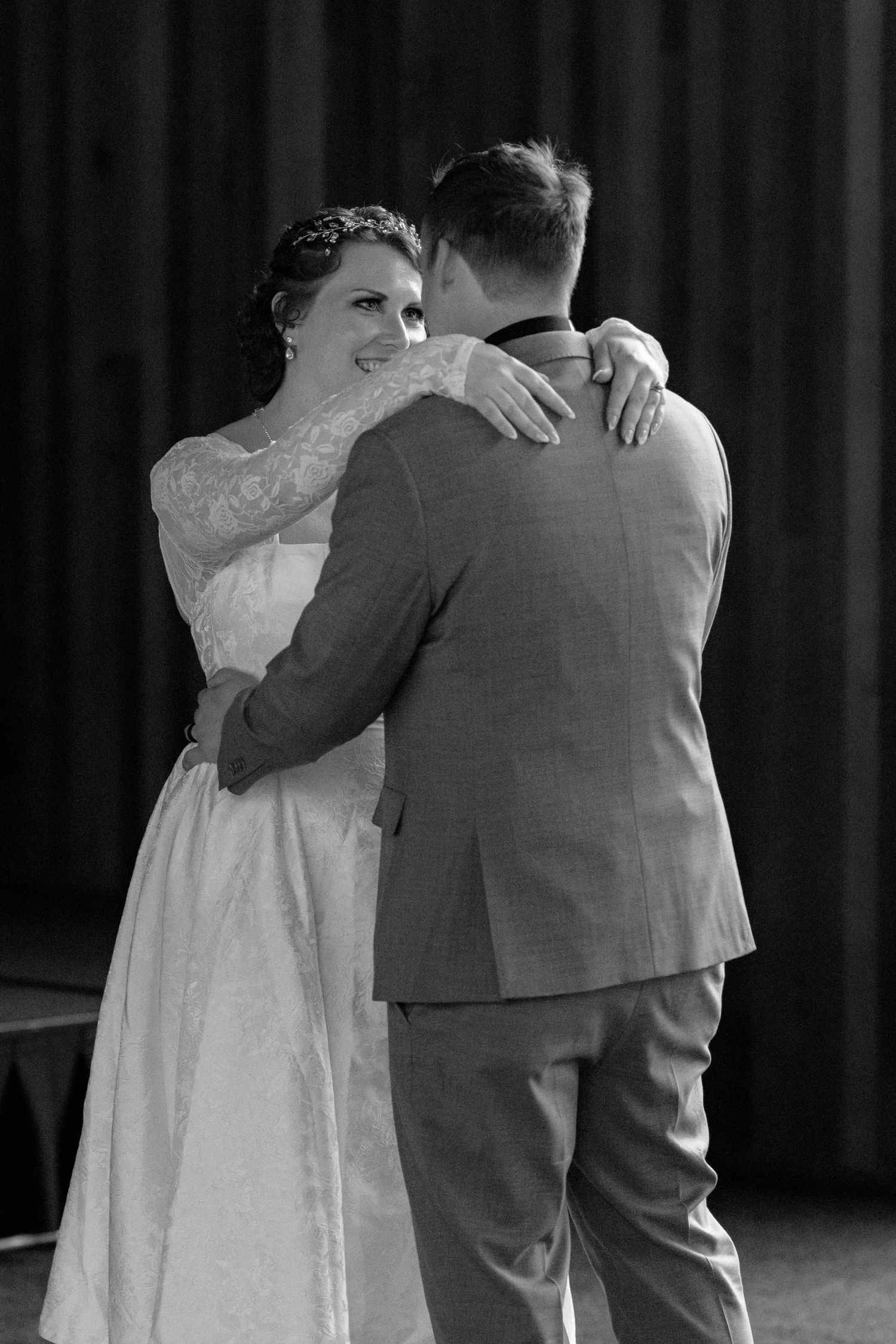 Bride and groom sharing their first dance in black and white wedding photo.