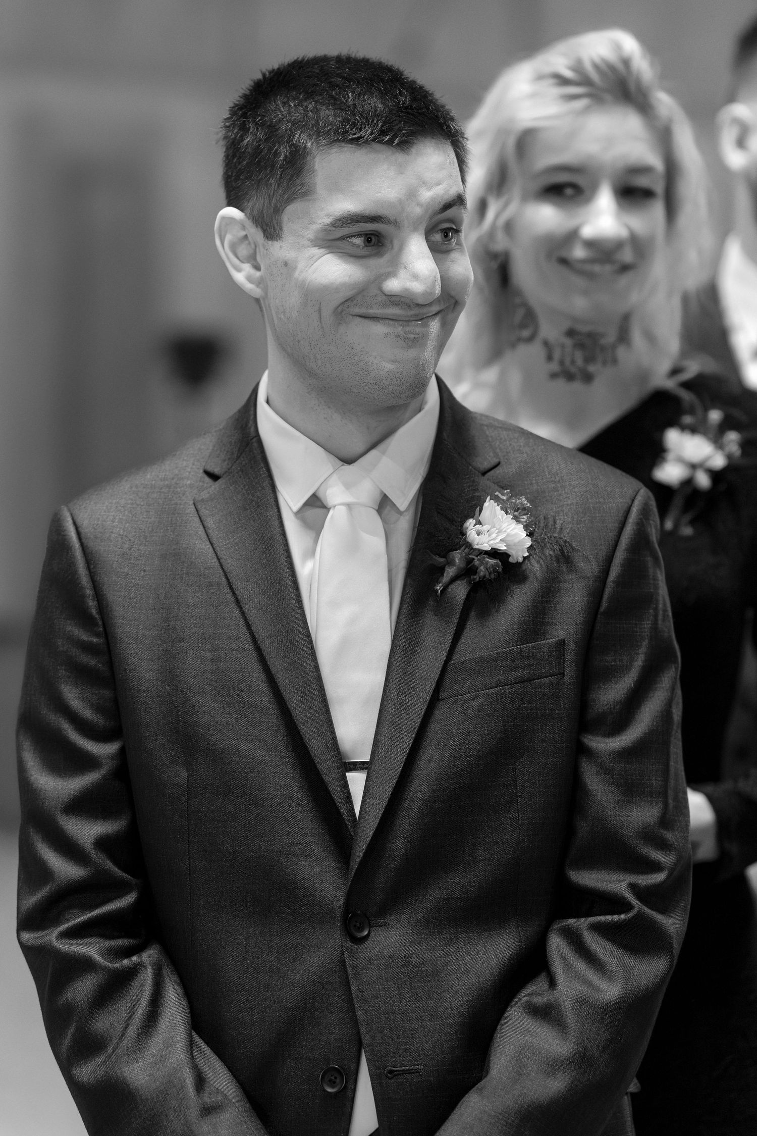 Black and white photo showing groomsmen in dark suits with white ties and boutonnieres.