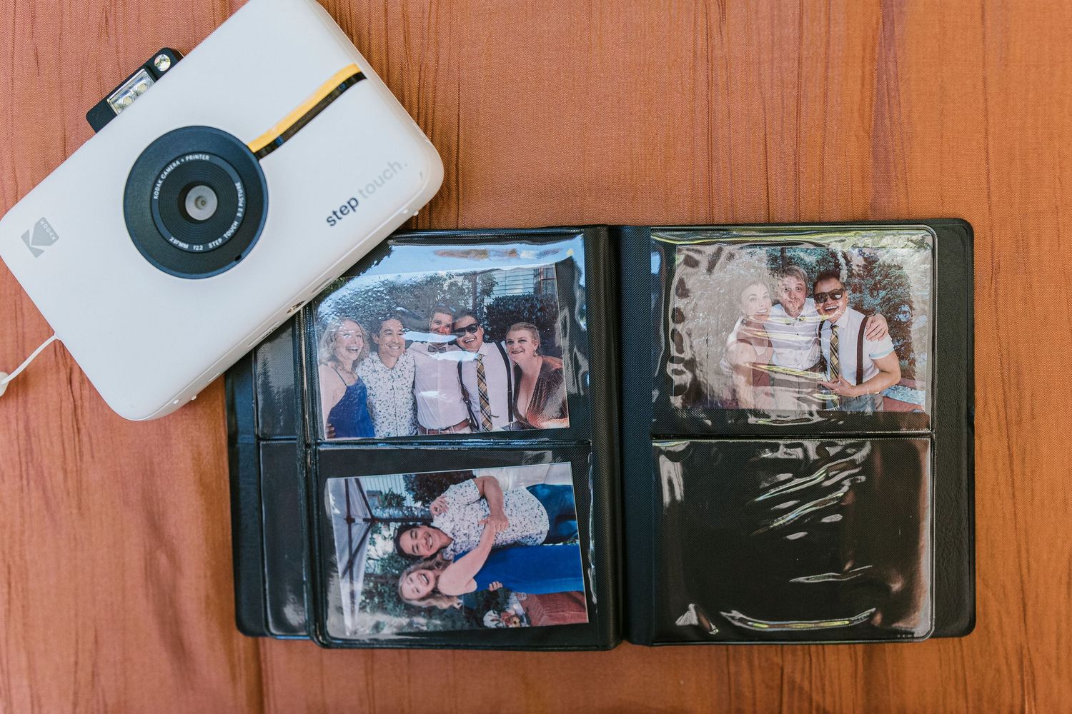 Photo album pages showing family snapshots and memories arranged in a vintage style on a wooden surface.