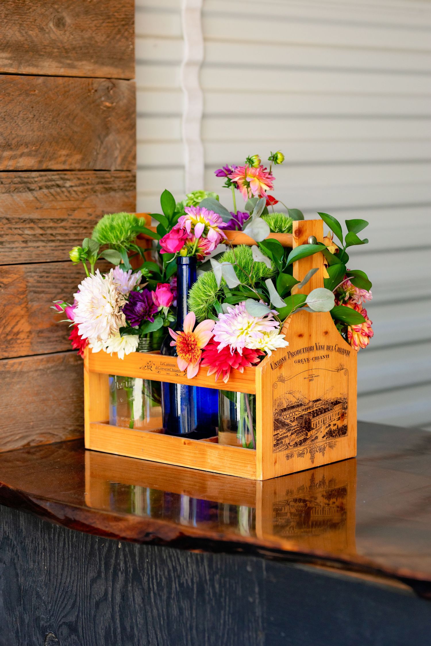Vibrant floral arrangement in wooden wine crate.