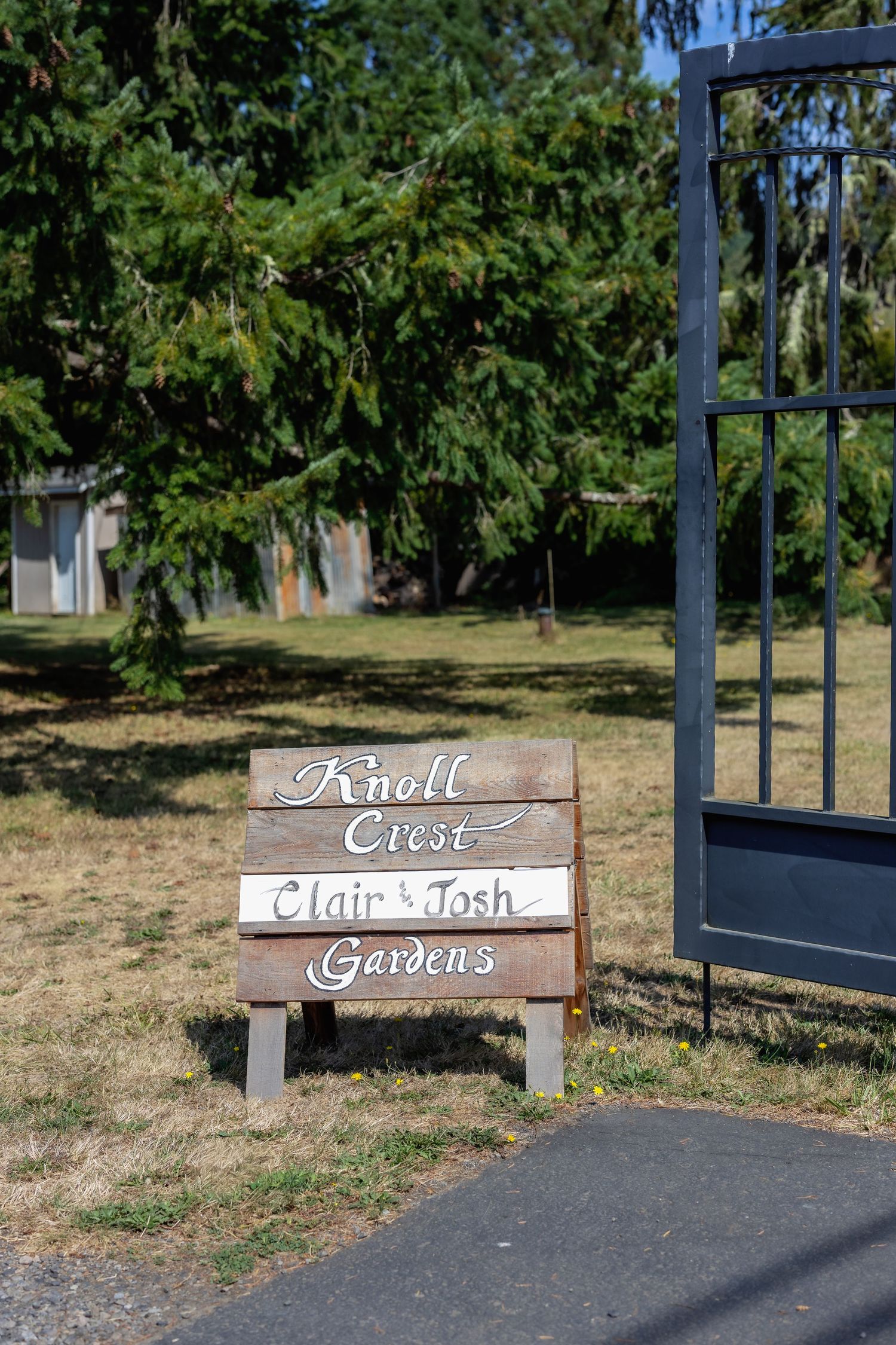 Wooden signs marking 'Knoll Gardens' displayed along a garden pathway.