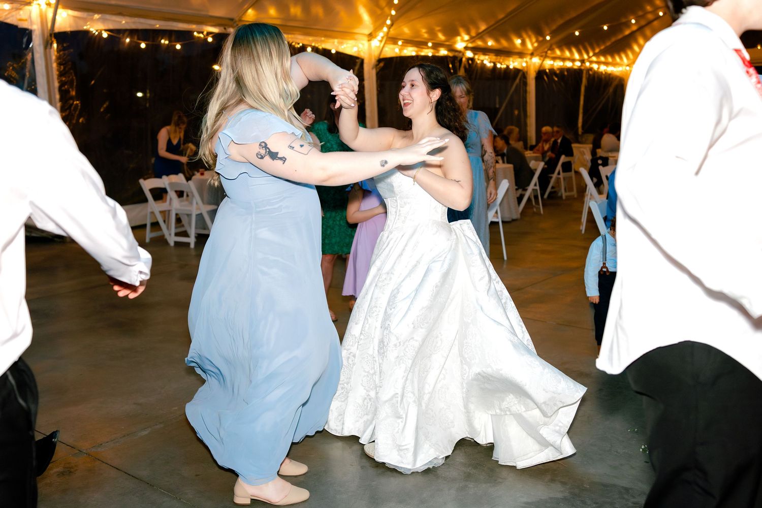 Couples dance together at a wedding reception under warm lighting in an elegant venue.