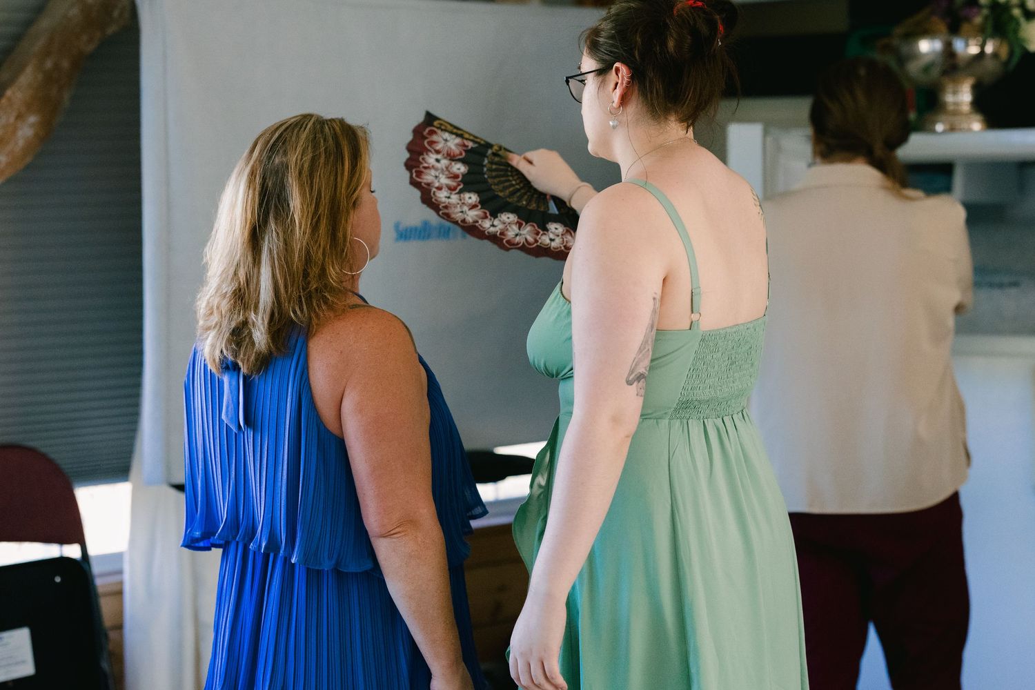 Wedding party members in blue and mint green dresses prepare for the ceremony.