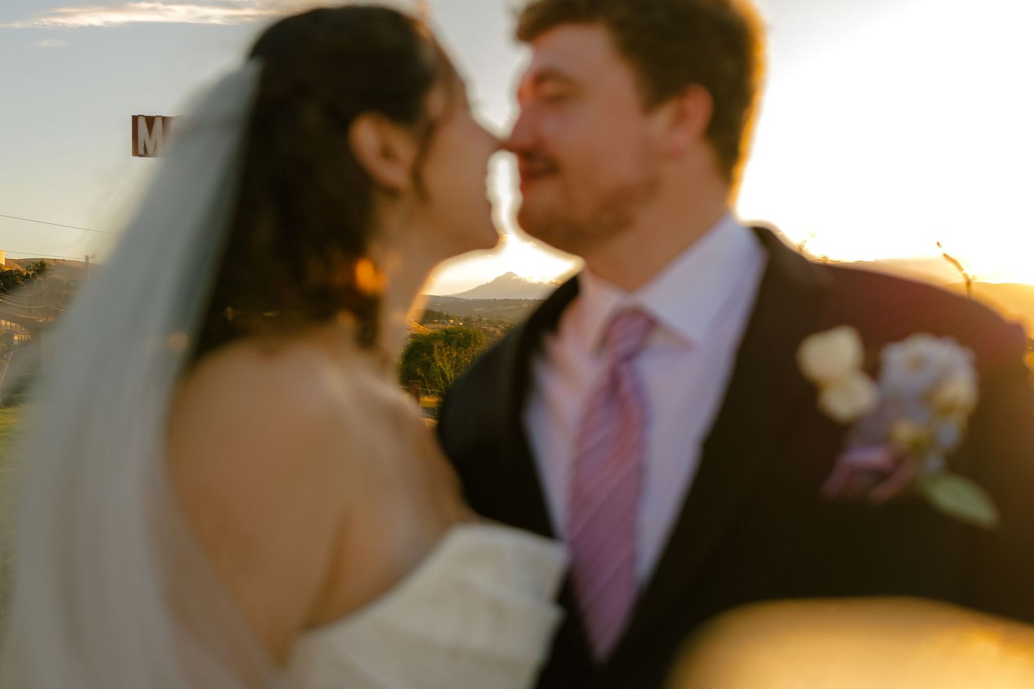 A romantic sunset moment captured at an outdoor wedding celebration.