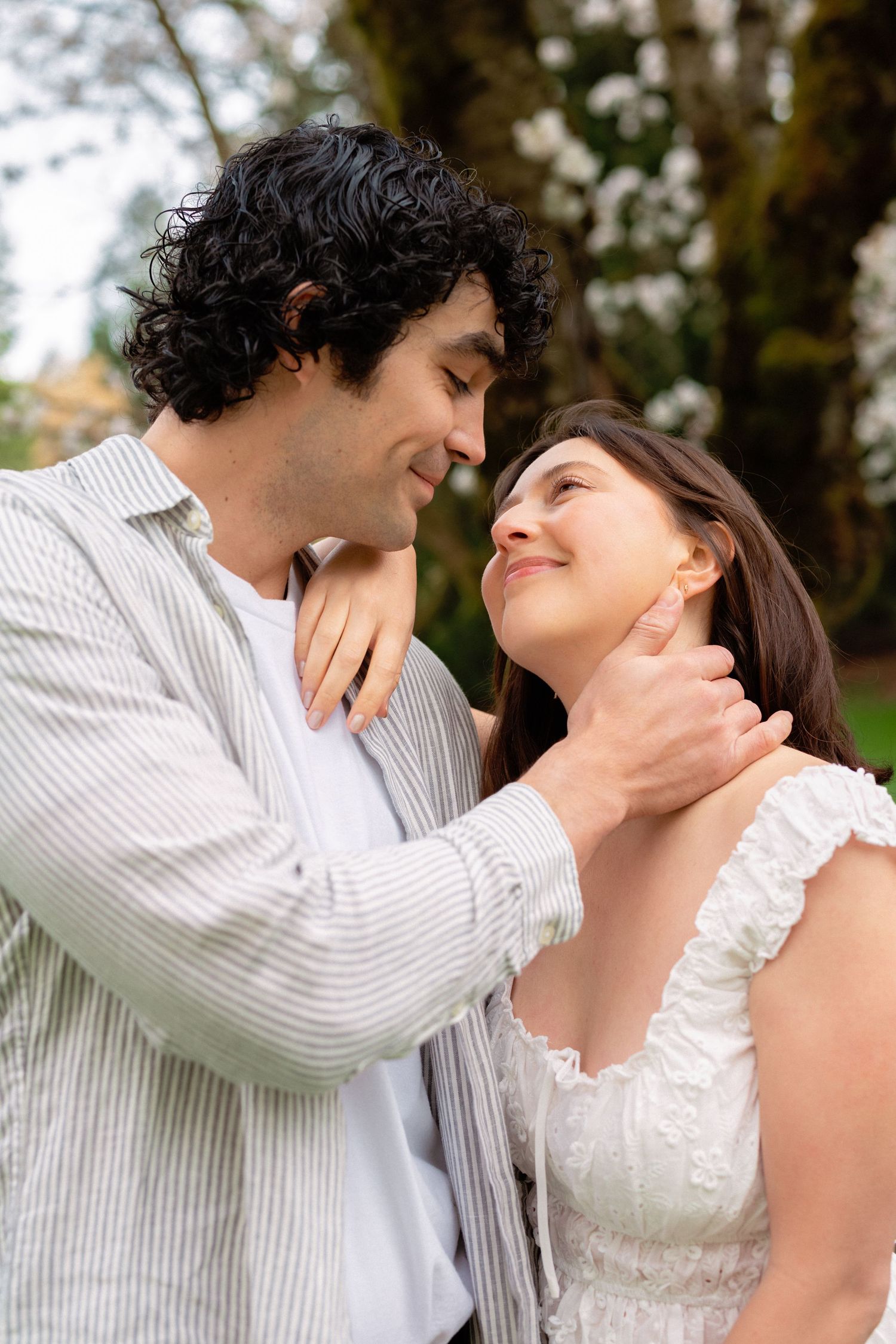 A tender romantic moment captured in close-up as a couple shares an intimate embrace outdoors.