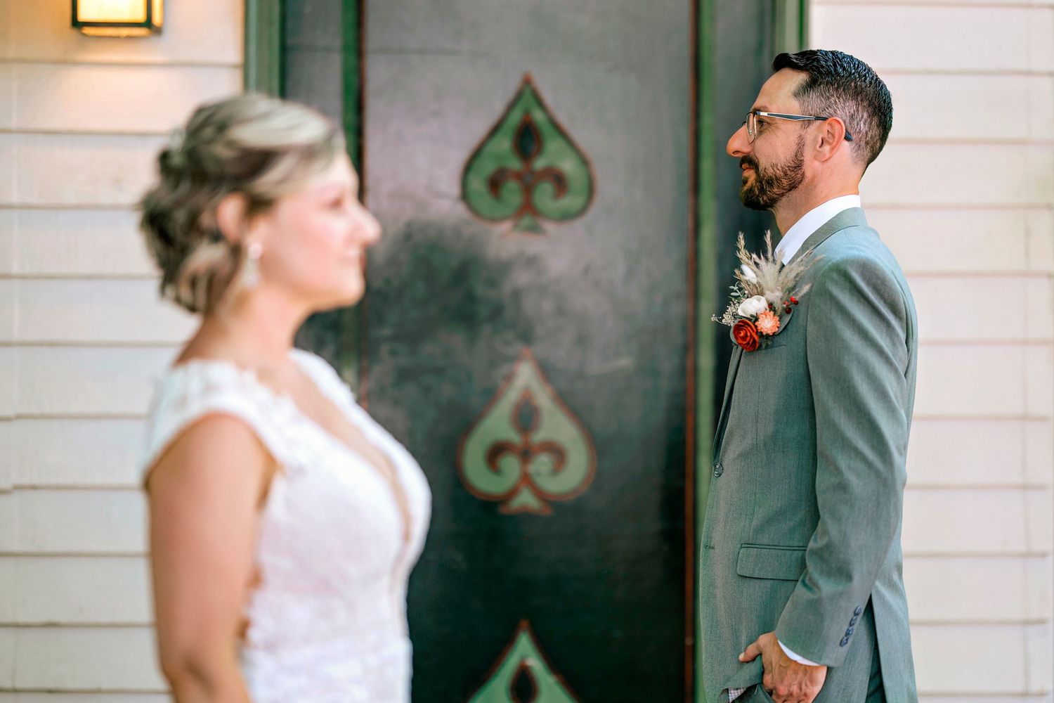 A series of romantic moments captured in front of a rustic white building with green trim.