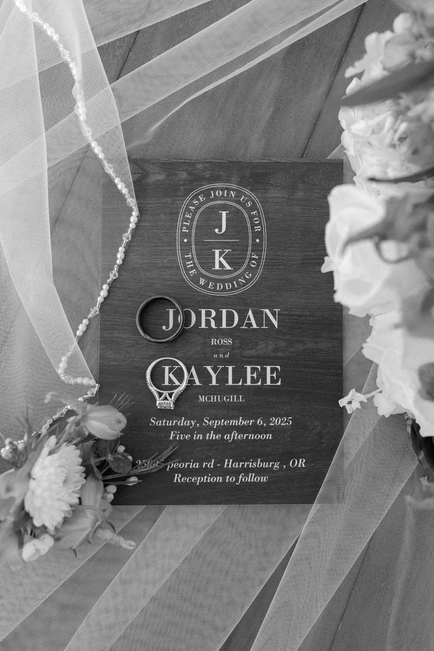 Wedding invitation design with monogram logo and text details in black and white overlay.
