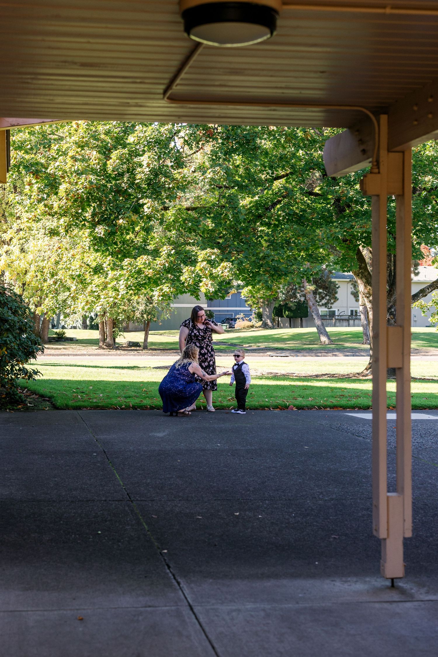 Covered outdoor pavilion area with green lawn and trees visible in background.